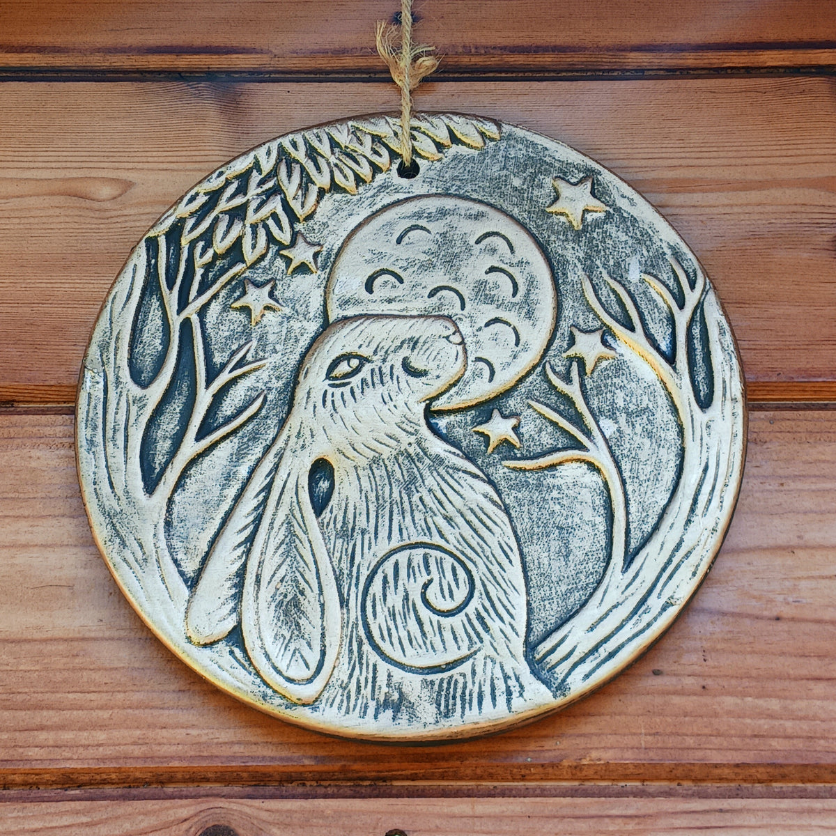 Add a touch of mystical woodland charm to your home with this beautiful Lisa Parker Moon Gazing Hare Terracotta Plaque. Featuring a striking hare gazing towards the moon, this circular decorative plaque has a distinctive copper-effect finish that gives it a warm, antique-inspired appearance.