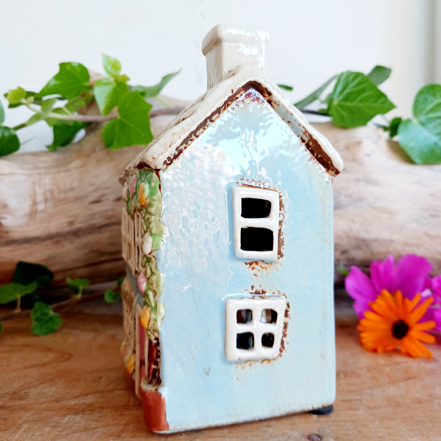 Welcome a touch of storybook charm into your home with the Village Pottery Village Stores Tealight Holder, a handcrafted ceramic delight glowing with the warmth of simpler times. Measuring 15.5 x 9.5 x 8 cm, this quaint miniature shop captures the heart of an old-fashioned village, complete with detailed windows, rustic roof tiles, and painted signage that evokes cosy nostalgia.