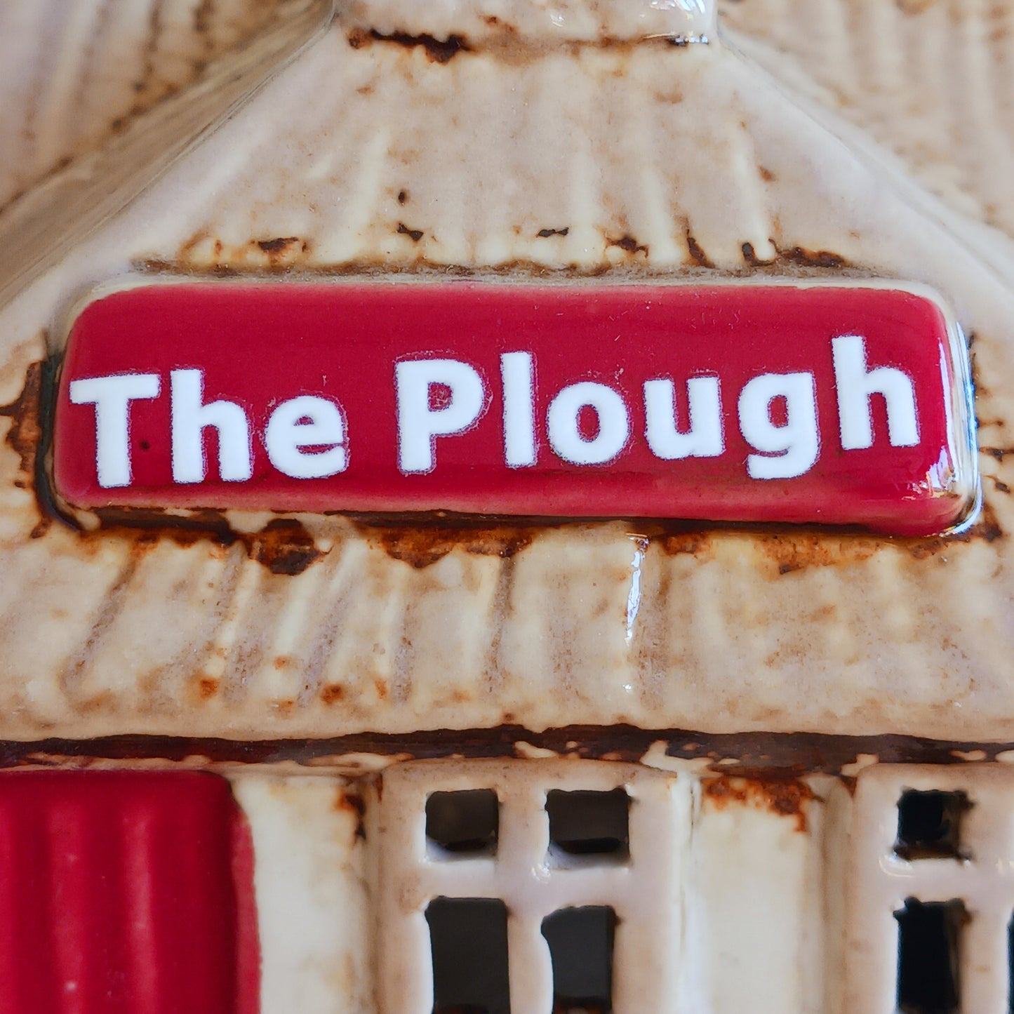 A hearth-lit gathering place where candlelight flickers like laughter carried on the evening air, the Croft Plough Pub brings rustic enchantment to your village scene. This Shudehill Village Pottery tealight house is crafted from ceramic, casting a warm, inviting glow through its windows to evoke comfort, connection, and quiet magic.
