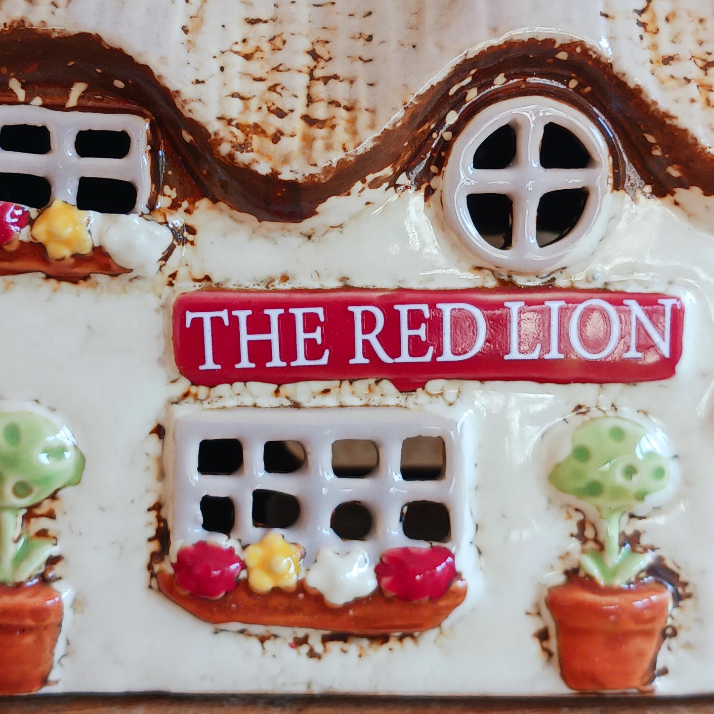 Illuminate your home with the charming Red Lion Pub Tealight Holder from the Village Pottery Collection. Crafted from quality ceramic, this delightful tealight holder adds warmth and character to any space. Perfect for creating your own enchanting village scene, it’s both a functional tealight holder and a decorative ornament.