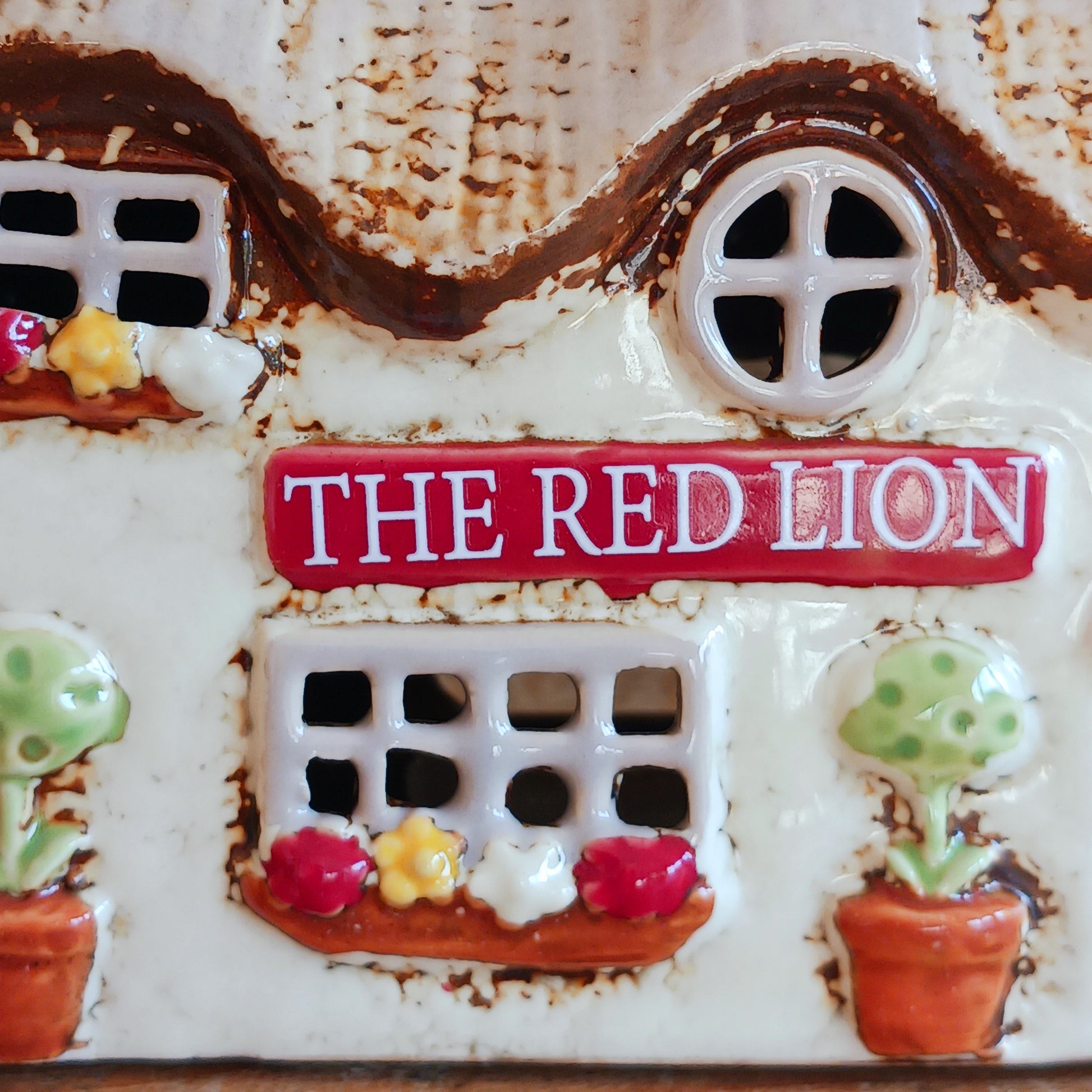 Illuminate your home with the charming Red Lion Pub Tealight Holder from the Village Pottery Collection. Crafted from quality ceramic, this delightful tealight holder adds warmth and character to any space. Perfect for creating your own enchanting village scene, it’s both a functional tealight holder and a decorative ornament.