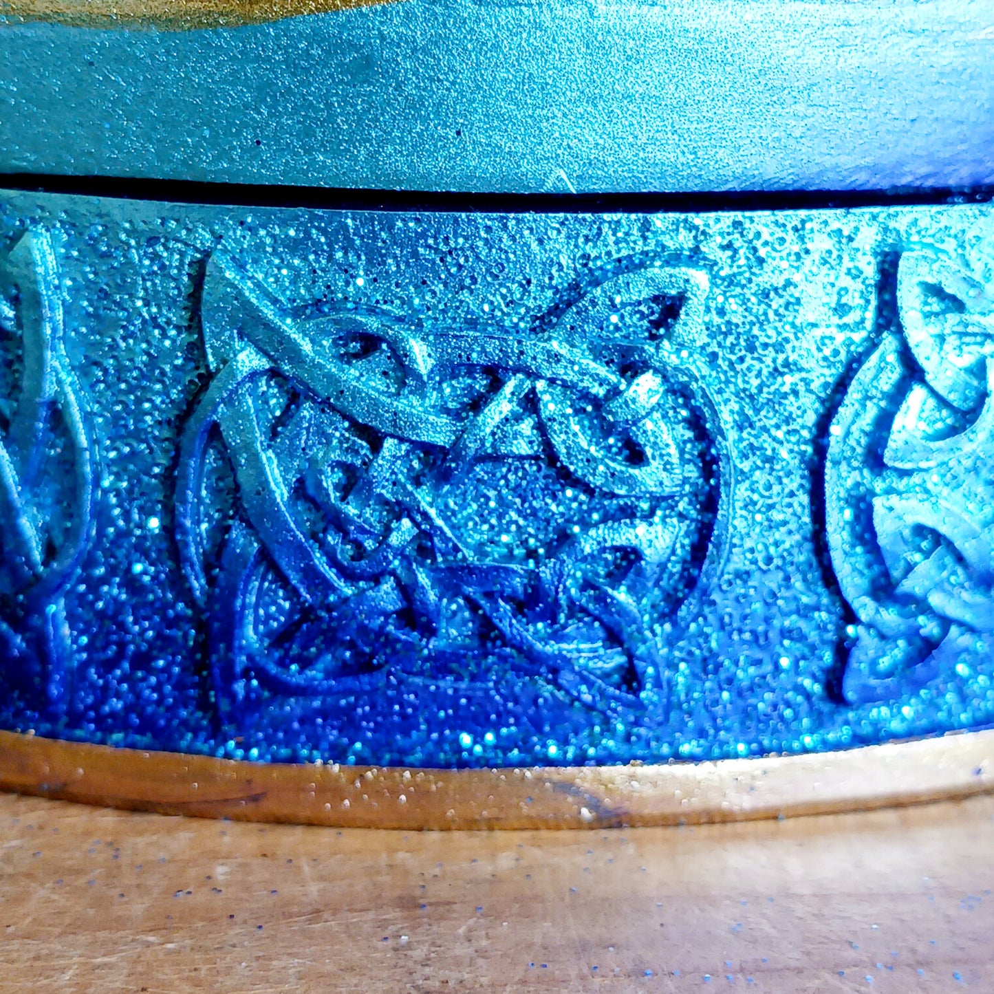 Safely store your small crystals, jewellery, or magical keepsakes in this enchanting&nbsp;Blue Crescent Moon Trinket Box. Crafted from durable cold-cast resin, this Wiccan-inspired box is shaped like a crescent moon and features a fully removable lid. The raised lid design showcases curled silver ribbons set against a deep blue background, framed with a matching border. Celtic knotwork patterns adorn the sides, adding a mystical charm.