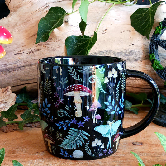 Bring a little woodland magic to your morning with this beautiful black ceramic mug featuring a mystical forest design. The fabulous print is filled with magical mushrooms, toadstools and enchanting forest flora and fauna, creating a wonderfully atmospheric mug for anyone who loves fantasy, nature and all things mystical.