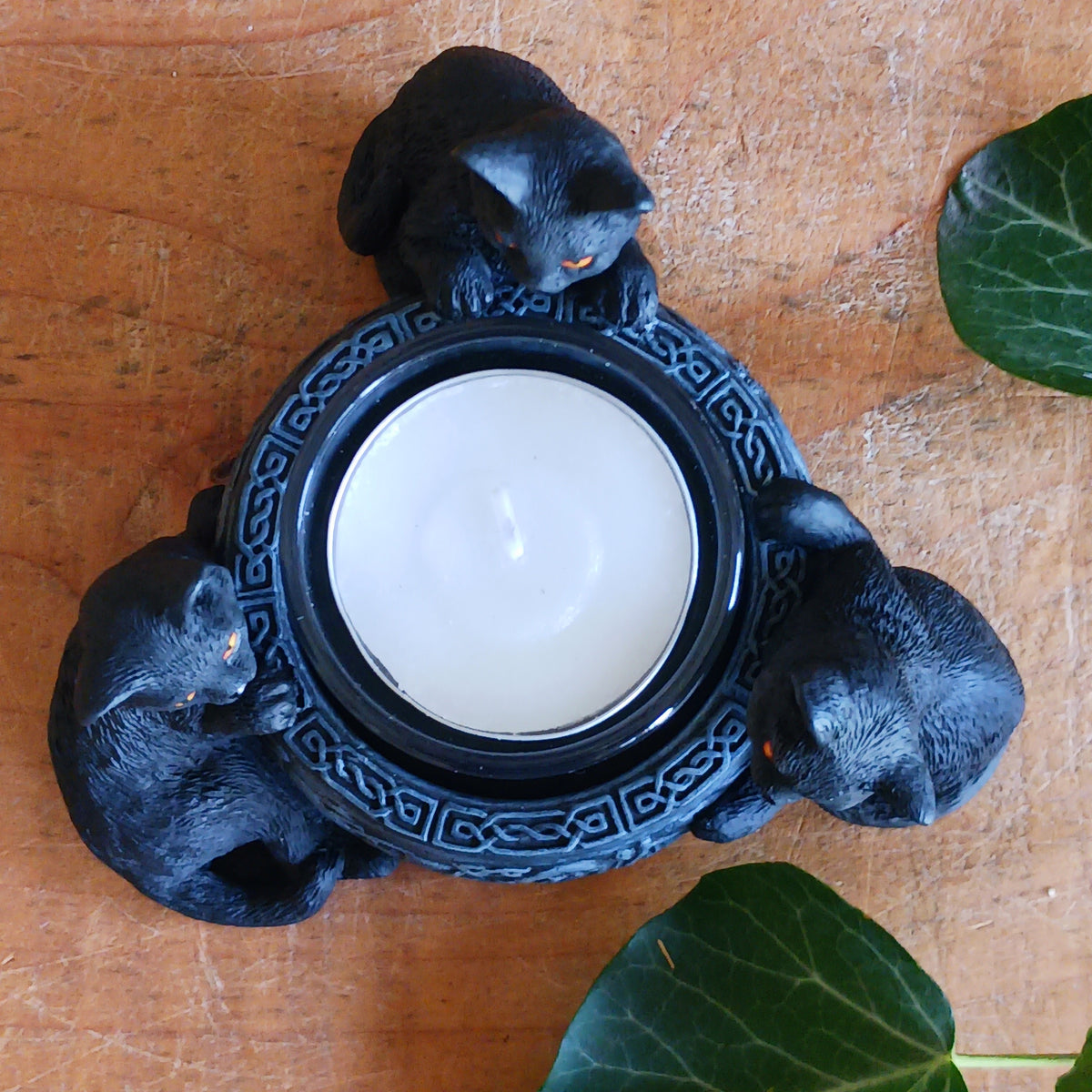 Bring a touch of playful witchcraft and gothic charm into your home with the Familiar Trio Tea Light Holder. Featuring three mischievous black cat familiars gathered around a central tealight, this enchanting candle holder creates a warm and atmospheric glow with plenty of magical character.