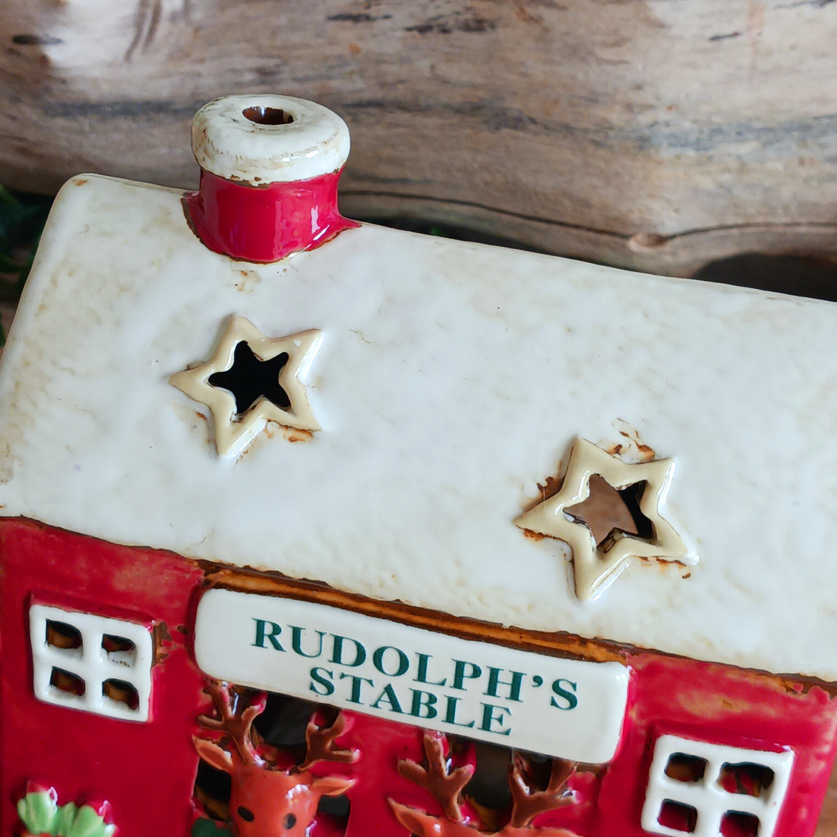 Bring a touch of festive village charm to your home with the Village Pottery Xmas Rudolph’s Stable Tealight Holder. This delightful ceramic Christmas decoration is designed as a quaint little stable, featuring a snowy roof, traditional green doors and charming reindeer detailing.