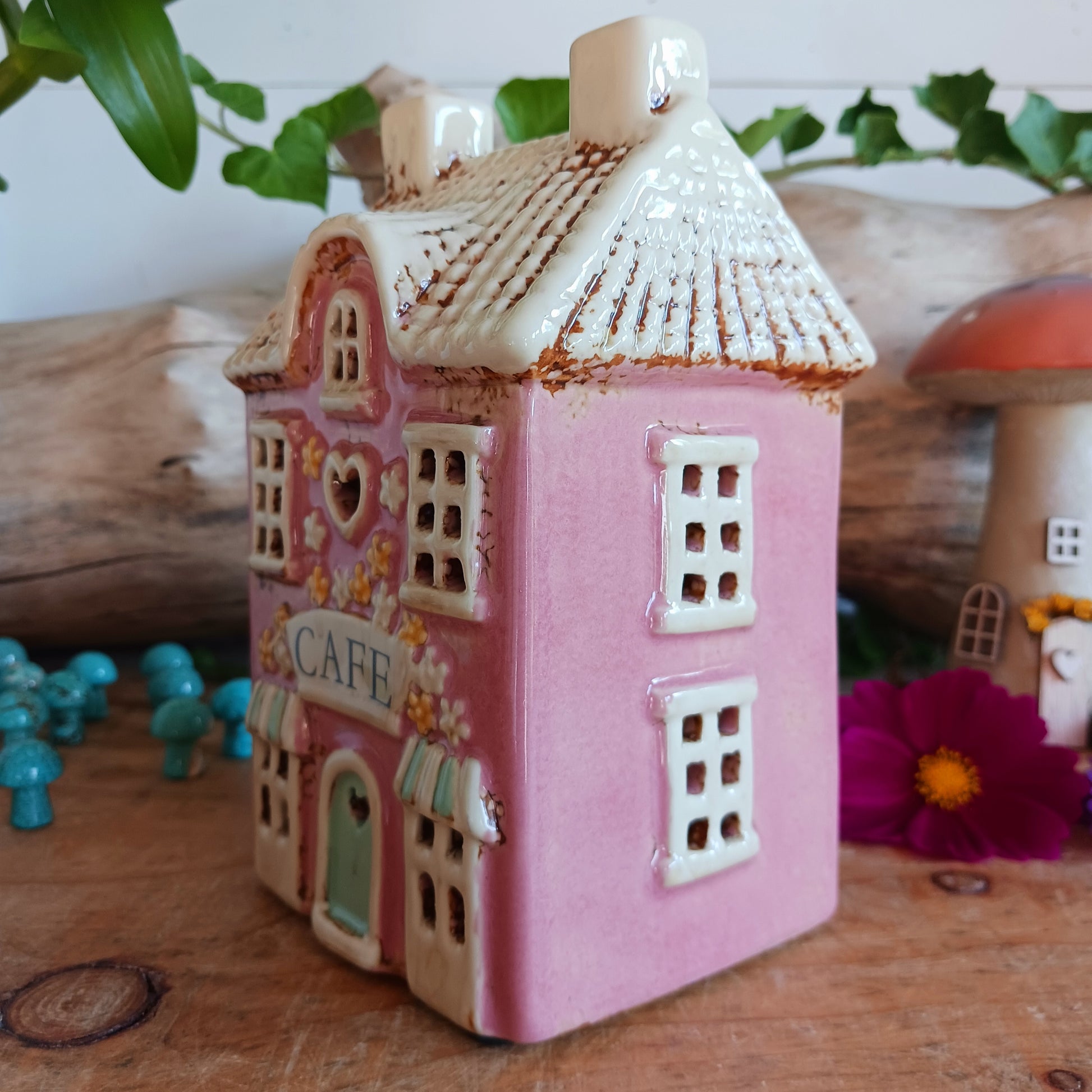 Illuminate your home with the charming Village Pottery Café Tealight Holder. Handcrafted with a rustic pink finish, this cosy piece adds warmth and ambience to any room. Perfect for tealights or simply as a decorative ornament, it’s a delightful addition to shelves, windowsills, or coffee tables. Pair with other pieces from the Village Pottery Collection to create your own quaint, decorative village.