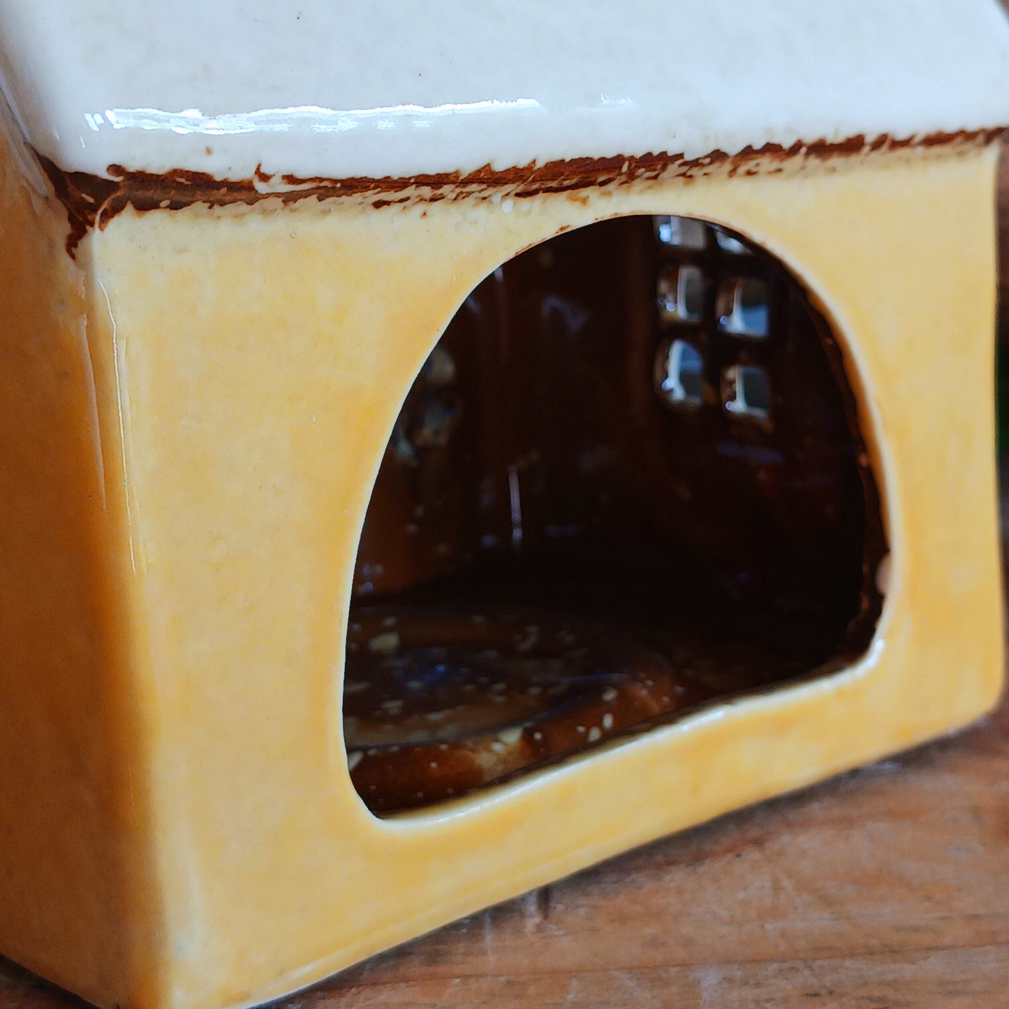 Add a whimsical touch to your décor with the Cards &amp; Gifts Tealight Holder from the Village Pottery Collection. Inspired by the charm of a cozy card shop in a quaint village, this ceramic piece features intricate detailing, from its bunting roof to its delicate windows. Perfect as a tealight holder or simply as a decorative ornament, it brings warmth and character to any space.