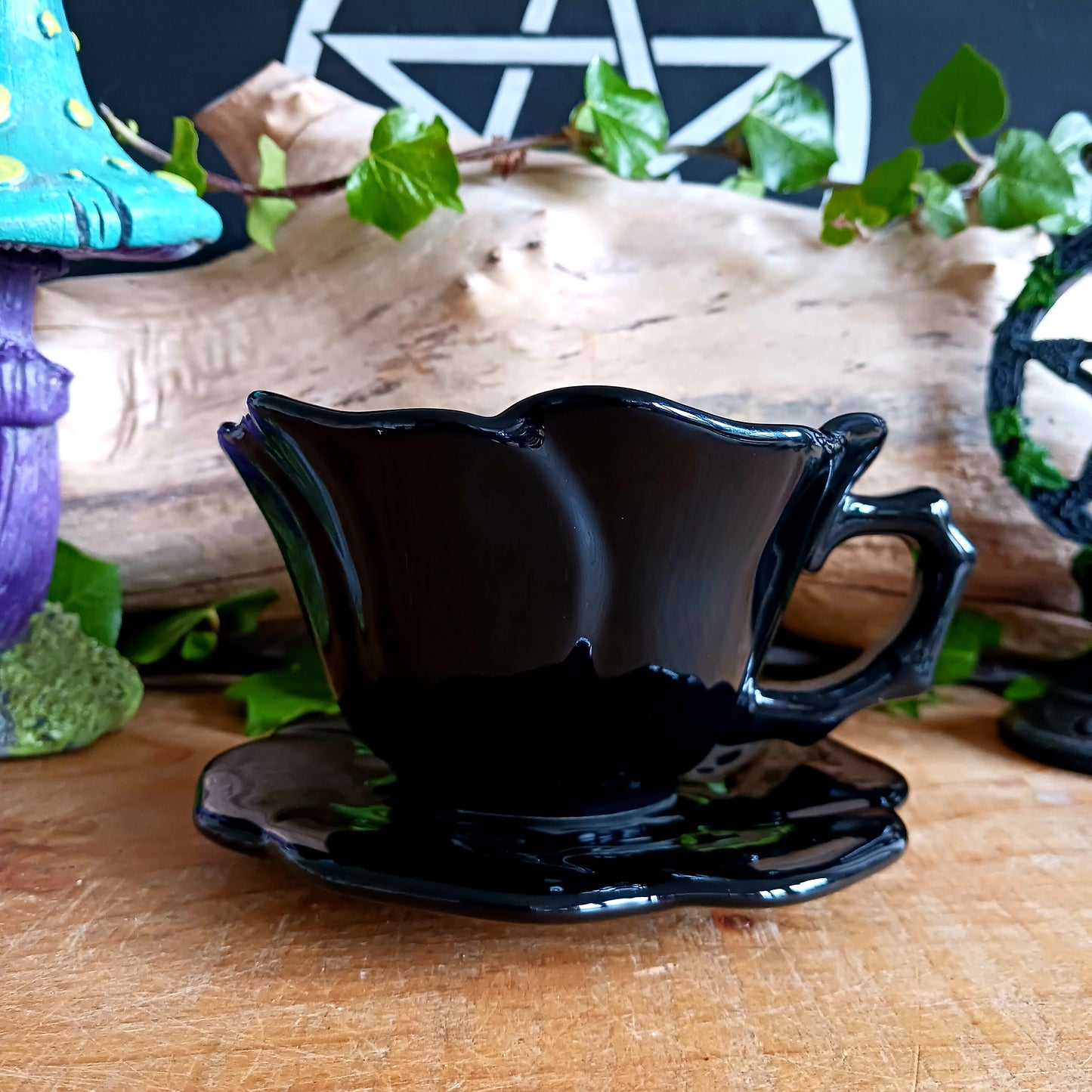 Summon timeless elegance with this black ceramic teacup and matching saucer, sculpted in the likeness of a dark, blooming rose. Designed with a dramatic silhouette and intricate petal detailing, this tea set transforms every sip into a ritual of gothic grace.