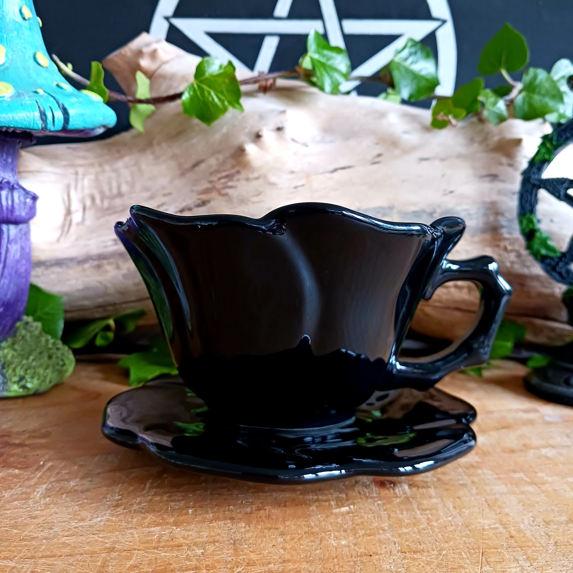 Summon timeless elegance with this black ceramic teacup and matching saucer, sculpted in the likeness of a dark, blooming rose. Designed with a dramatic silhouette and intricate petal detailing, this tea set transforms every sip into a ritual of gothic grace.