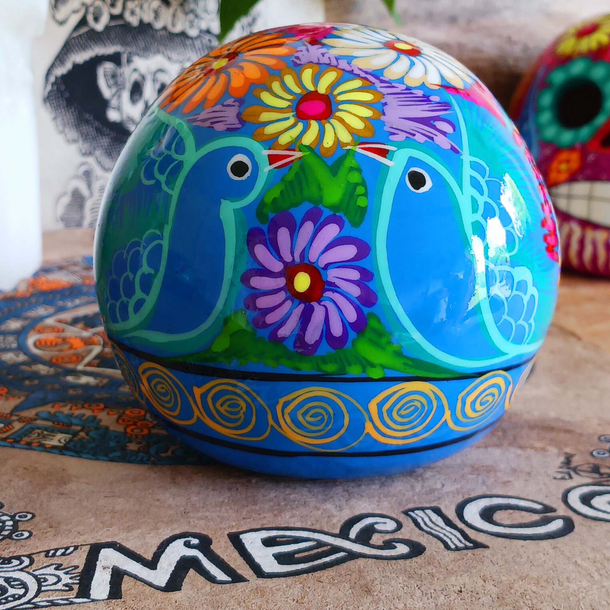 These fun ceramic sugar skull ornaments have been beautifully painted in bright colours and finished with a high shine glaze. They are a popular item during Día de Los Muertos or Day of the Dead festivities, held in Mexico every November to celebrate welcoming the souls of their deceased relatives back for a time of food, drink and celebration.