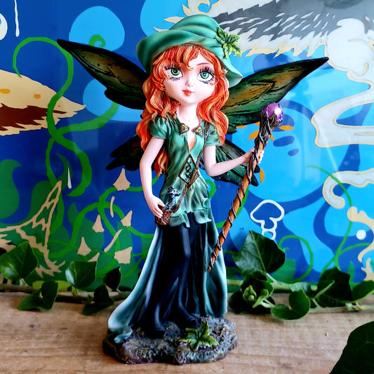 Meet Forest Fae, the whimsical guardian of the woods. This stunning standing fairy figurine captures the perfect blend of natural beauty and kawaii charm. Hand-painted with exquisite detail, she wears a lush forest green outfit, accented by leaf-shaped brooches, and holds a mystical staff crowned with a purple jewel. 