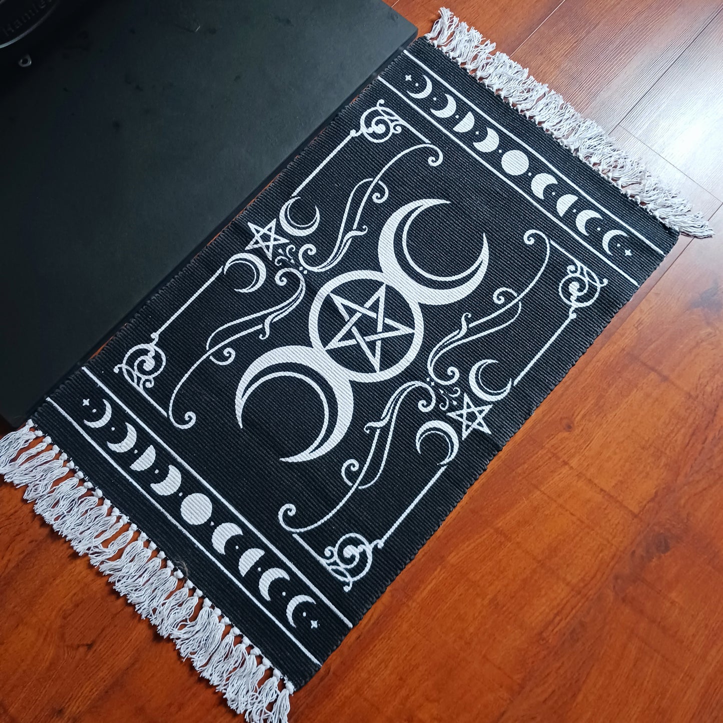 Invoke the sacred power of the lunar goddess with this Alchemy Gothic handwoven rug, beautifully depicting the eternal archetypes of Maiden, Mother, and Crone. Aligned with the moon's phases, this mystical tapestry blends symbolic femininity with ancient pagan wisdom, framed by the powerful elemental pentacle.