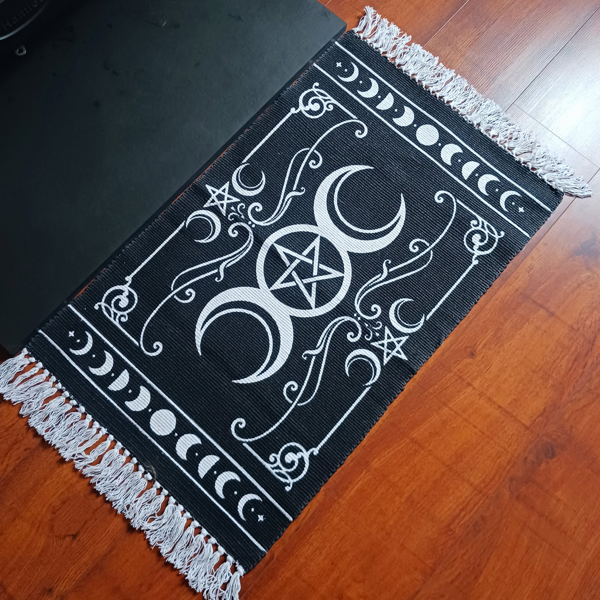 Invoke the sacred power of the lunar goddess with this Alchemy Gothic handwoven rug, beautifully depicting the eternal archetypes of Maiden, Mother, and Crone. Aligned with the moon's phases, this mystical tapestry blends symbolic femininity with ancient pagan wisdom, framed by the powerful elemental pentacle.
