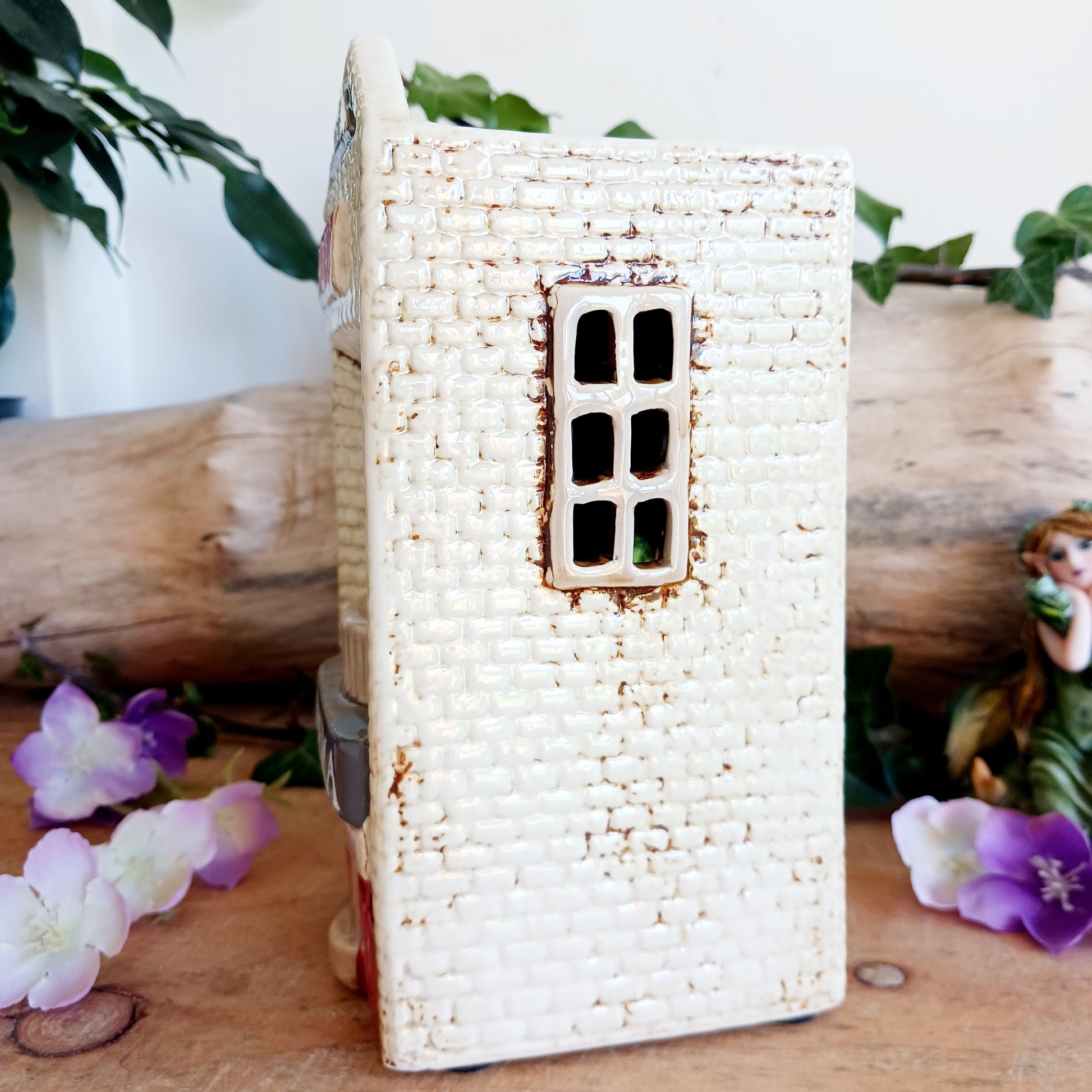 Step into a twilight screening where candlelight flickers like scenes upon an unseen reel. The Shudehill Village Pottery Roxy Cinema tealight house is crafted from ceramic, casting a soft glow through its windows to evoke a nostalgic yet enchanted village night.