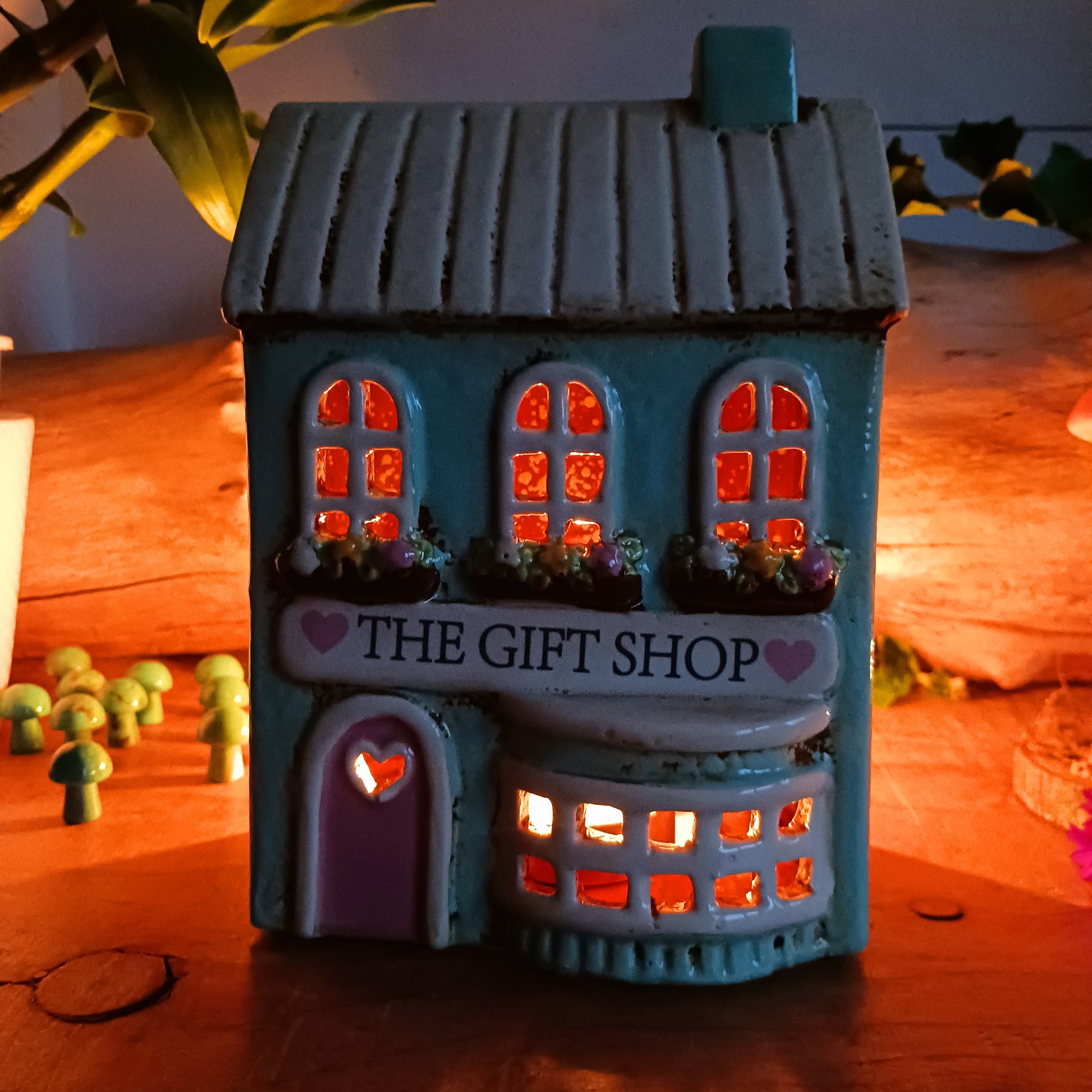 Transform your home into a warm and inviting sanctuary with the Village Pottery Gift Shop Tealight Holder. Crafted from quality ceramic, this charming piece creates a cosy, nostalgic glow when lit with a tealight. More than just a candle holder, it doubles as a delightful decorative ornament for your coffee table, shelf, or windowsill.