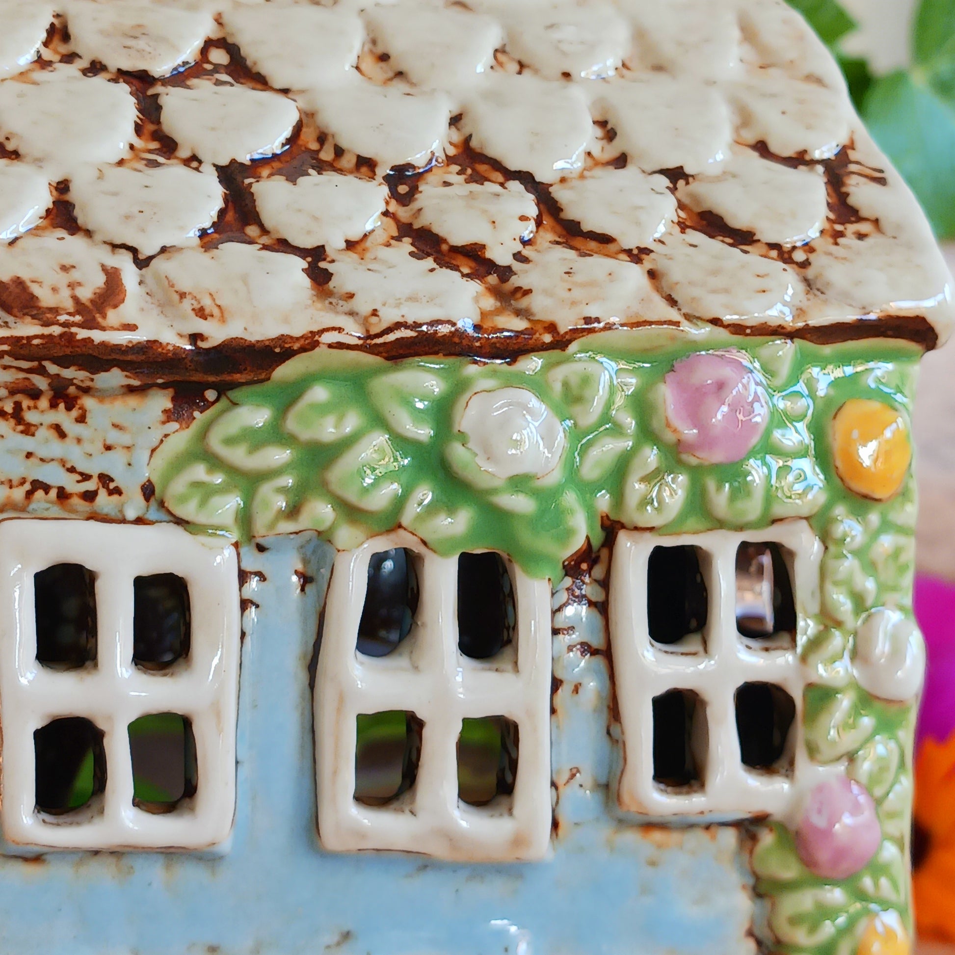 Welcome a touch of storybook charm into your home with the Village Pottery Village Stores Tealight Holder, a handcrafted ceramic delight glowing with the warmth of simpler times. Measuring 15.5 x 9.5 x 8 cm, this quaint miniature shop captures the heart of an old-fashioned village, complete with detailed windows, rustic roof tiles, and painted signage that evokes cosy nostalgia.