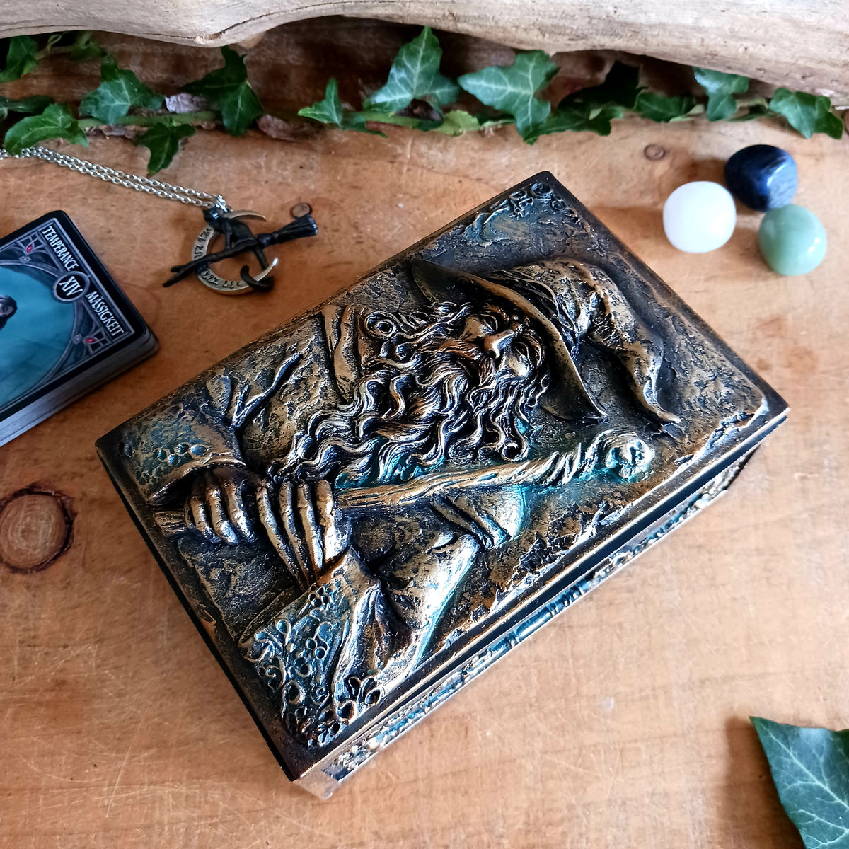 Bring a little magic and mystery into your home with the enchanting Wizard’s Hoard Box. Featuring a beautifully sculpted wizard clutching a magical staff, this decorative trinket box is surrounded by intricate mystical detailing and finished in a rich, antique gold-like colour.