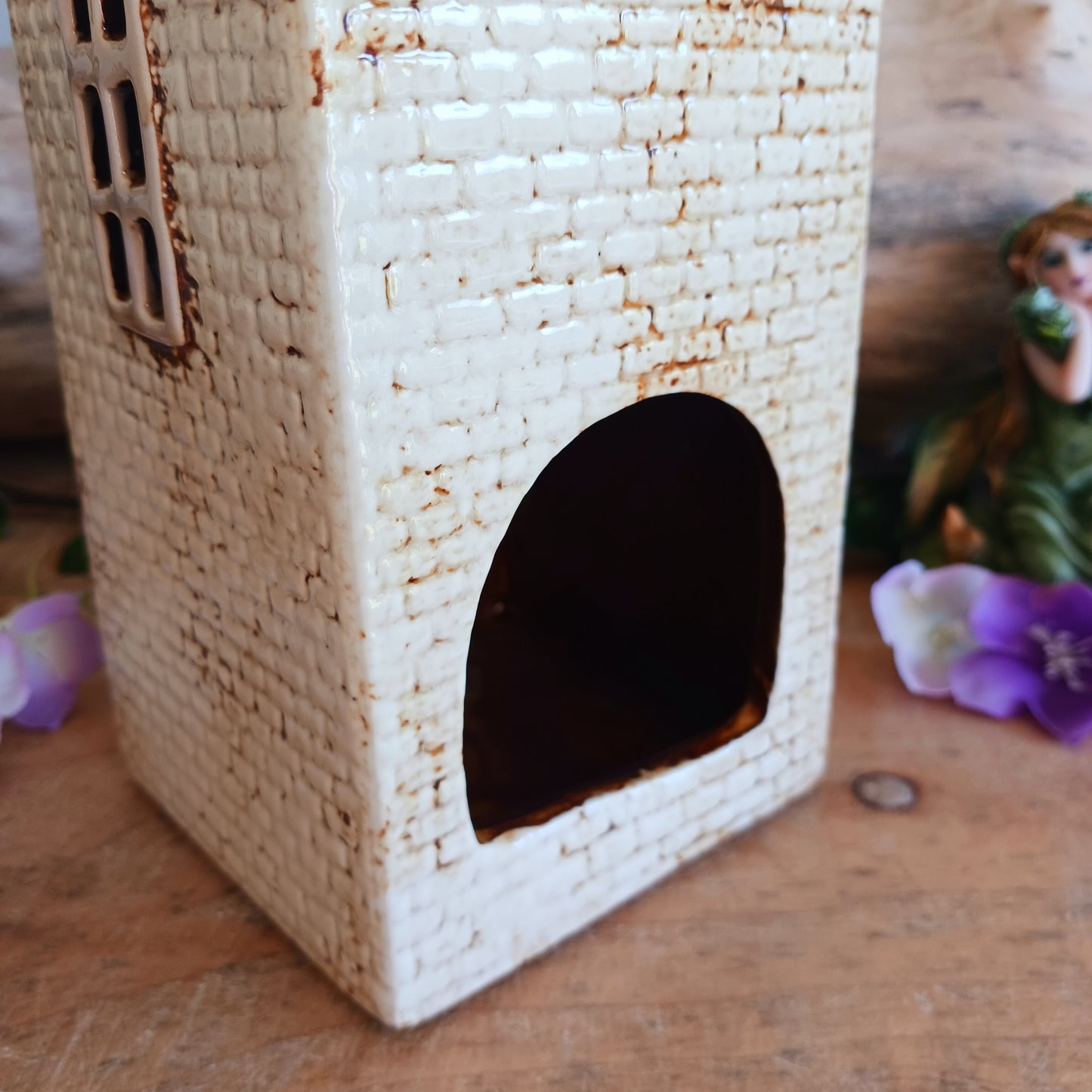 Step into a twilight screening where candlelight flickers like scenes upon an unseen reel. The Shudehill Village Pottery Roxy Cinema tealight house is crafted from ceramic, casting a soft glow through its windows to evoke a nostalgic yet enchanted village night.