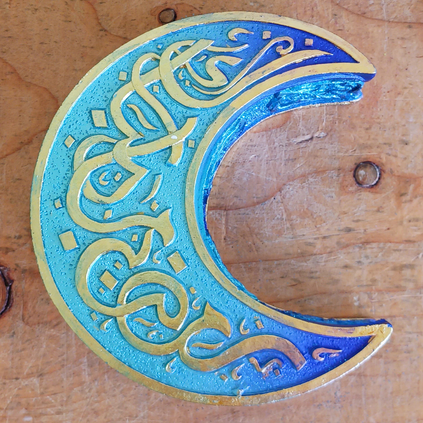 Safely store your small crystals, jewellery, or magical keepsakes in this enchanting&nbsp;Blue Crescent Moon Trinket Box. Crafted from durable cold-cast resin, this Wiccan-inspired box is shaped like a crescent moon and features a fully removable lid. The raised lid design showcases curled silver ribbons set against a deep blue background, framed with a matching border. Celtic knotwork patterns adorn the sides, adding a mystical charm.