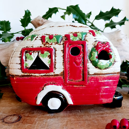 Step into a cosy winter wonderland with the Village Pottery Christmas Caravan Tealight Holder, a heart-warming piece crafted with love and festive magic. Measuring 13.5 x 18.5 x 7 cm, this hand-painted ceramic caravan glows with Christmas cheer, ready to light up your home with a gentle, enchanting flicker.