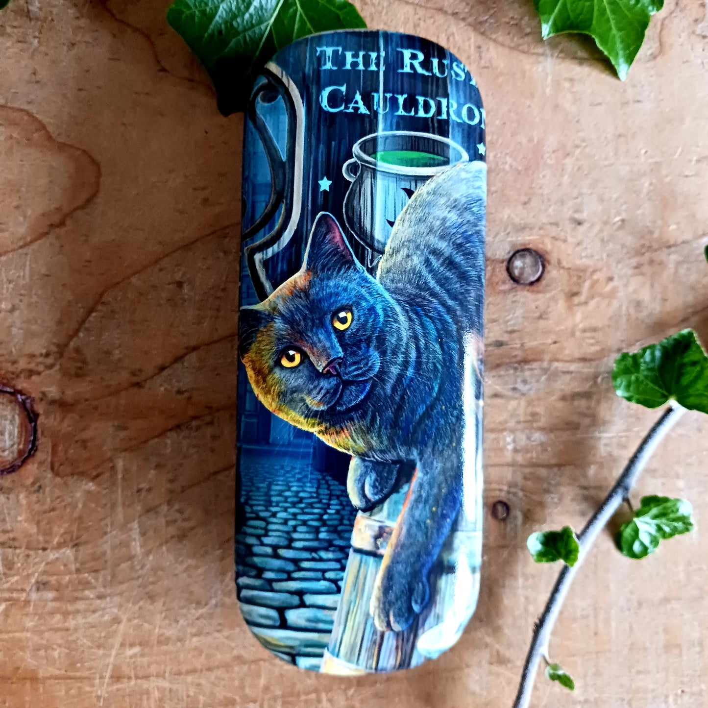 Protect your spectacles in enchanting style with this hard shell glasses case featuring Lisa Parker’s ‘Rusty Cauldron’ artwork. Designed to guard your eyewear from scratches, pressure, and everyday wear, this sturdy case is perfect for handbags, backpacks, or bedside storage.