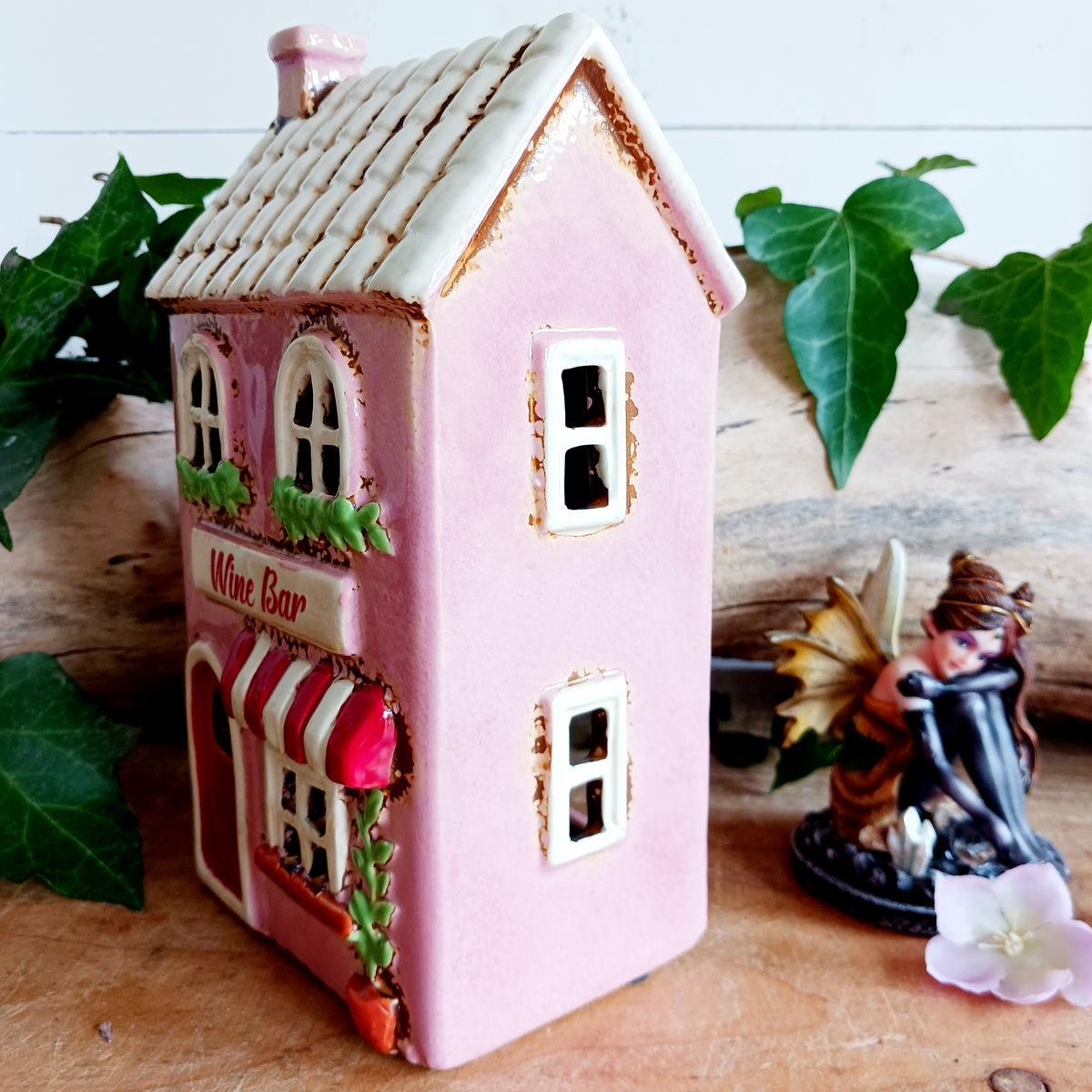 Bring the charm of a quaint village high street into your home with this delightful Village Pottery Wine Bar Tealight Holder. Hand-crafted from ceramic and beautifully hand-painted, this charming miniature wine bar is packed with character and intricate details.