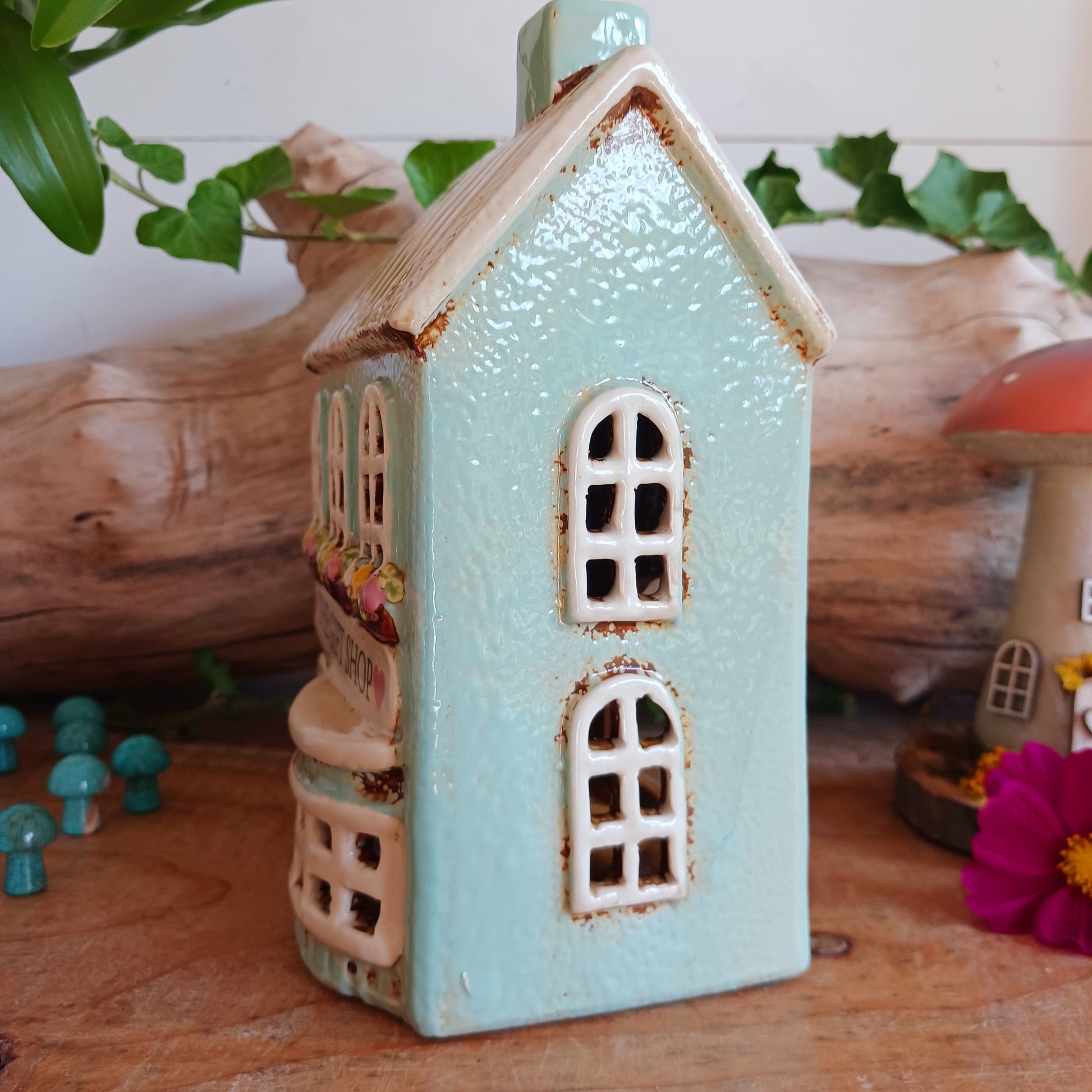 Transform your home into a warm and inviting sanctuary with the Village Pottery Gift Shop Tealight Holder. Crafted from quality ceramic, this charming piece creates a cosy, nostalgic glow when lit with a tealight. More than just a candle holder, it doubles as a delightful decorative ornament for your coffee table, shelf, or windowsill.