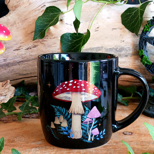 Add a touch of woodland enchantment to your morning coffee or evening cuppa with this beautiful Dark Forest Mushroom Ceramic Mug. Featuring an intricate mushroom design inspired by mystical forests, this black ceramic mug is decorated with a magical crescent moon and twinkling stars.