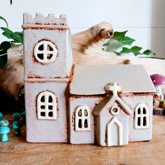 Bring warmth, charm, and a touch of history to your home with the Village Pottery Norman Church Tealight. Inspired by classic Norman architecture, this handcrafted ceramic tealight holder features arched windows and a timeless bell tower, reminiscent of a tranquil countryside church.