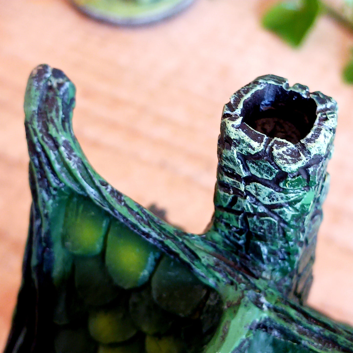 Step into a magical, enchanted forest with this beautiful gothic-style fairy cottage. Designed with a pointed roof adorned in dark green, scale-like shingles, this stunning piece glows warmly with LED lights shining through medieval-style windows. Sculpted vines and twisting tree roots climb the sides, while curled roof details add an intricate, whimsical finish.