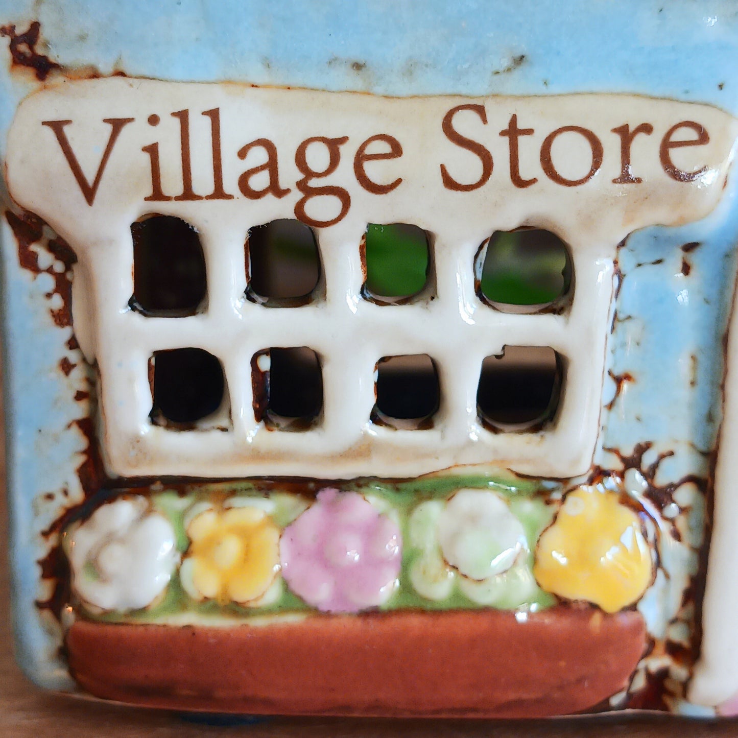 Welcome a touch of storybook charm into your home with the Village Pottery Village Stores Tealight Holder, a handcrafted ceramic delight glowing with the warmth of simpler times. Measuring 15.5 x 9.5 x 8 cm, this quaint miniature shop captures the heart of an old-fashioned village, complete with detailed windows, rustic roof tiles, and painted signage that evokes cosy nostalgia.