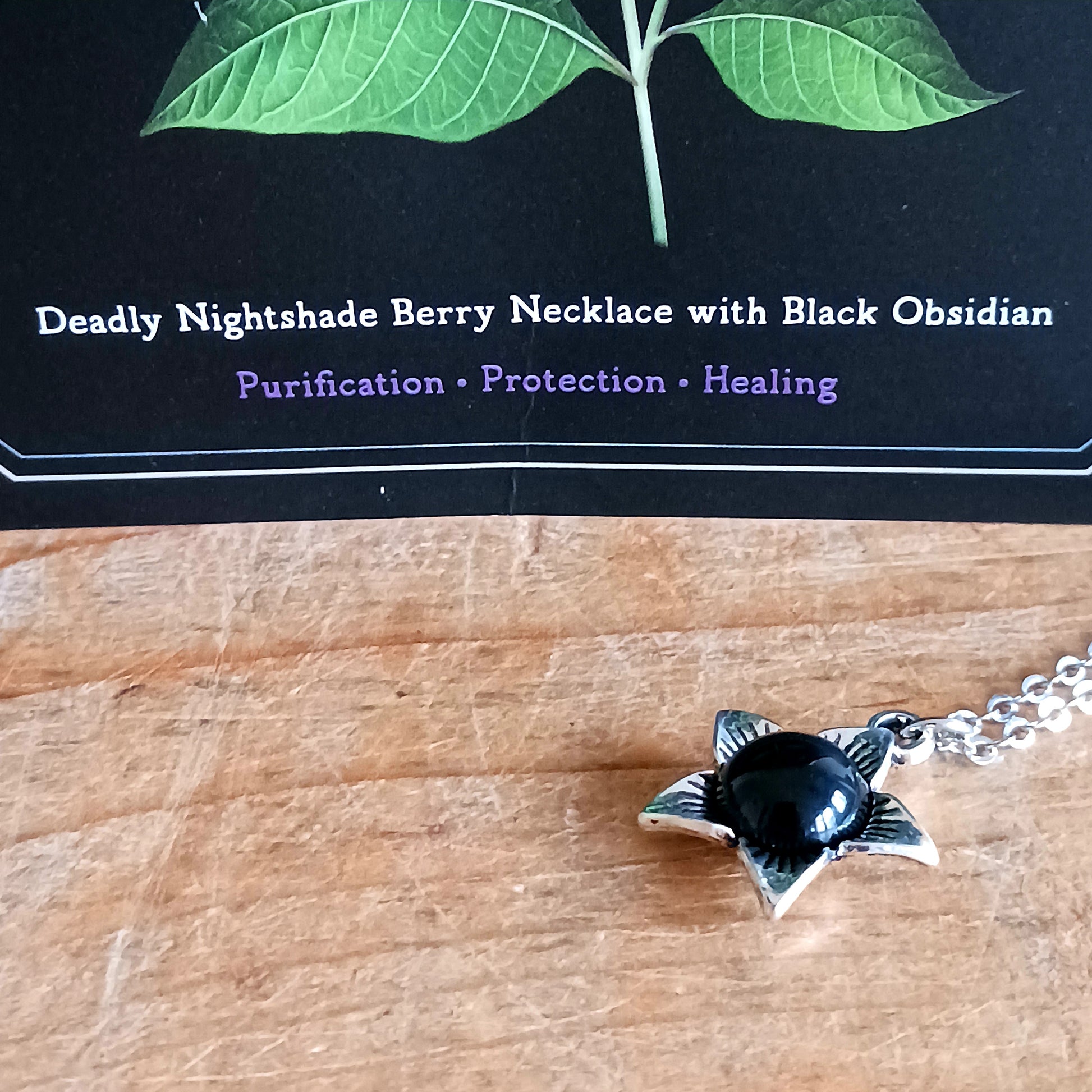 The Deadly Nightshade Necklace with Black Obsidian is a piece of dark elegance, blending nature’s shadowed beauty with gothic symbolism.
