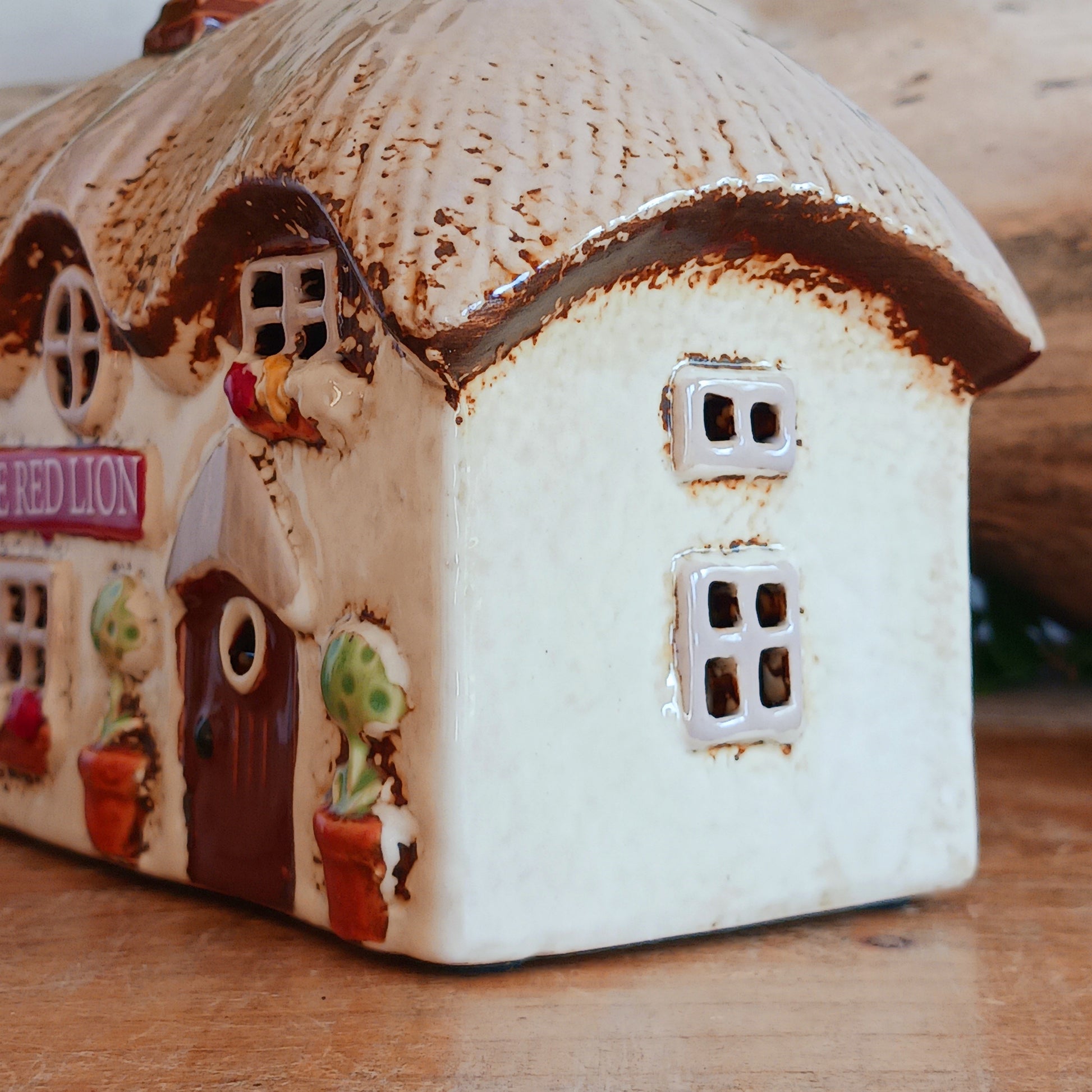 Illuminate your home with the charming Red Lion Pub Tealight Holder from the Village Pottery Collection. Crafted from quality ceramic, this delightful tealight holder adds warmth and character to any space. Perfect for creating your own enchanting village scene, it’s both a functional tealight holder and a decorative ornament.