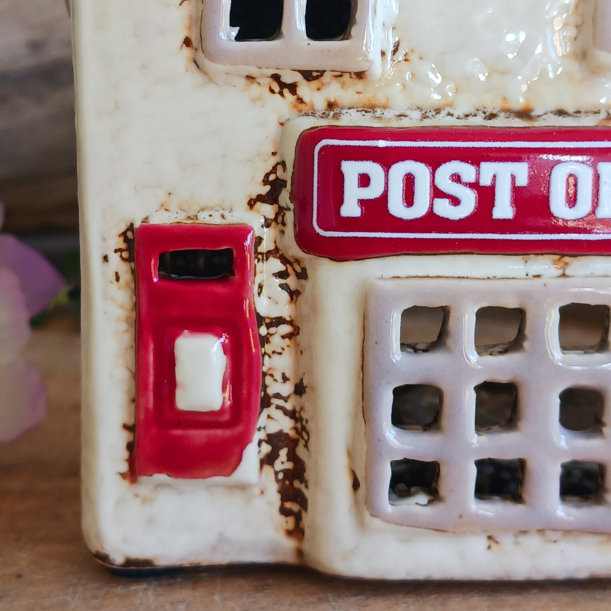 Whispers travel by candlelight from this Village Pottery Post Office tealight house, where tiny windows glow like messages carried between realms. Crafted from ceramic and measuring 12x15x7cm, this enchanting piece brings warmth and quiet magic to your sacred space.