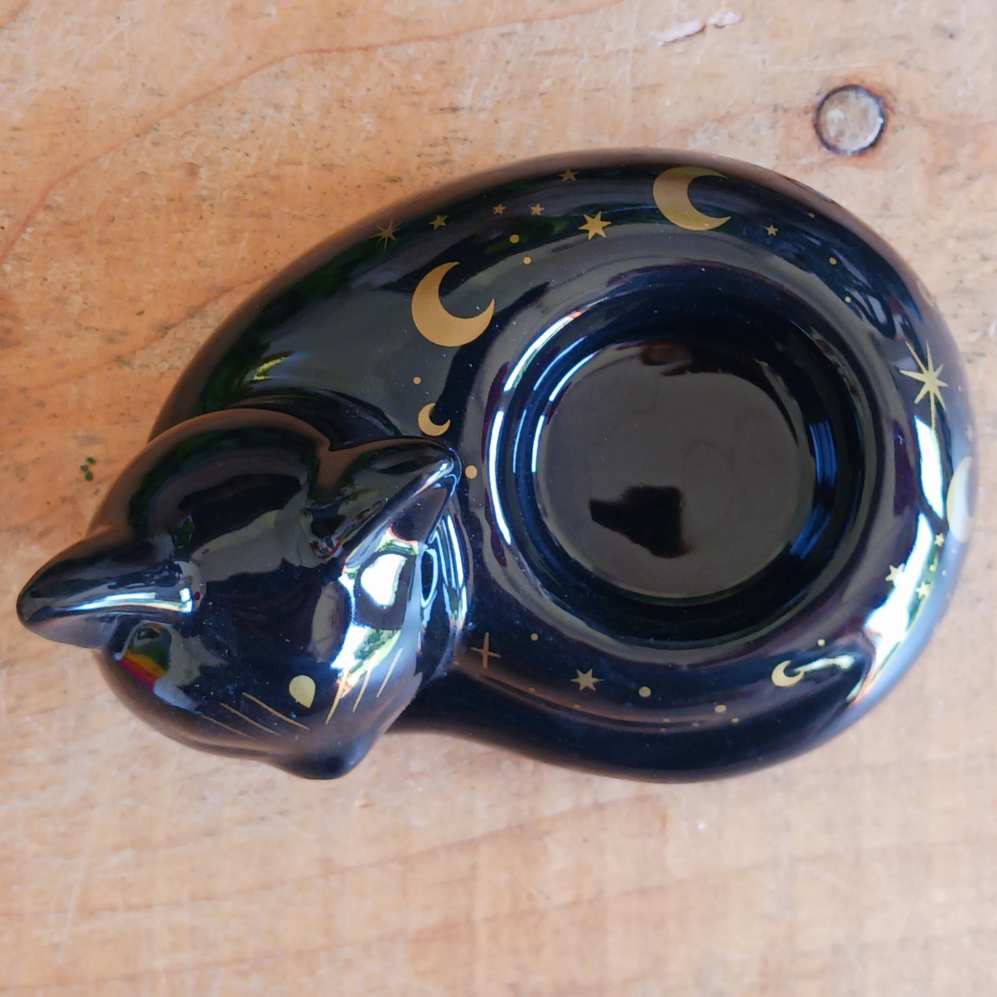 Create a warm and mystical atmosphere with this charming black cat ceramic tealight holder. Designed in the shape of a peacefully curled cat, this decorative candle holder adds a soft flickering glow to shelves, bedside tables, altars, and cosy corners of your home.