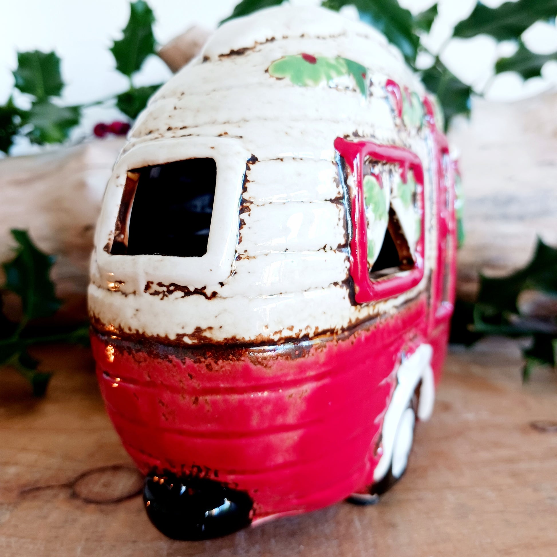 Step into a cosy winter wonderland with the Village Pottery Christmas Caravan Tealight Holder, a heart-warming piece crafted with love and festive magic. Measuring 13.5 x 18.5 x 7 cm, this hand-painted ceramic caravan glows with Christmas cheer, ready to light up your home with a gentle, enchanting flicker.