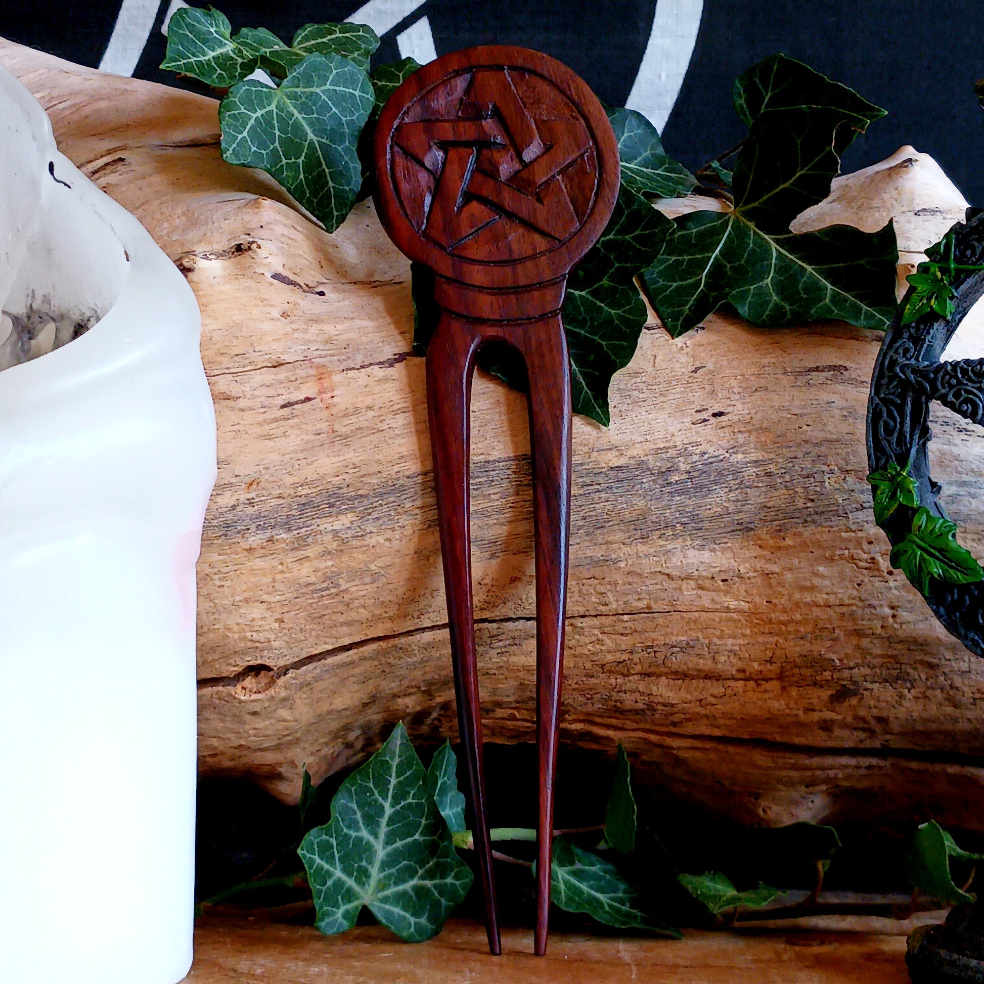 Slip into a realm of whispered enchantments with the Pentacle Design Hair Fork. Handcrafted from rich, dark natural wood, its elegant two-pronged form tucks smoothly into your hair, offering both beauty and balance.