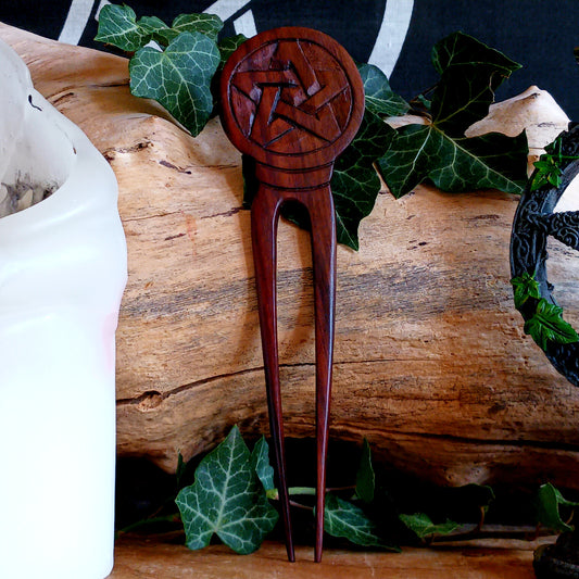 Slip into a realm of whispered enchantments with the Pentacle Design Hair Fork. Handcrafted from rich, dark natural wood, its elegant two-pronged form tucks smoothly into your hair, offering both beauty and balance.