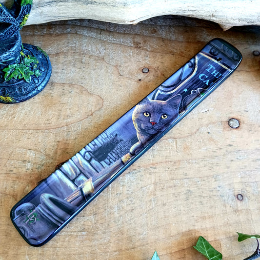 Bring a touch of magic into your home with the enchanting Rusty Cauldron Incense Burner by renowned fantasy artist Lisa Parker. Featuring her iconic artwork, this beautifully crafted piece captures a mystical feline perched atop a barrel outside the legendary Rusty Cauldron, while another curious cat watches the magical high street unfold behind.