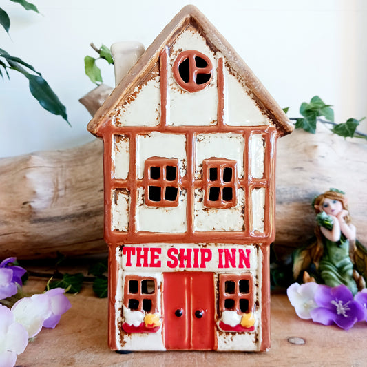 A lantern-lit refuge upon an enchanted street, the Tudor Ship Inn glows with the warmth of stories carried on twilight air. This Shudehill Village Pottery tealight house is crafted from ceramic, its windows flickering with candlelight like a haven for wandering souls.