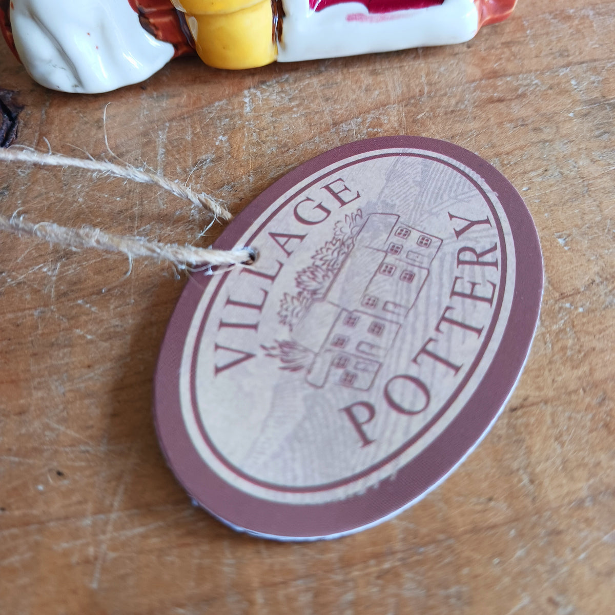 Bring a touch of village charm to your home with the Village Pottery Newsagent Tealight Holder. Beautifully designed as a traditional little village newsagent, this charming ceramic tealight holder features a warm red-brick façade, textured cream tiled roof and cheerful bright red front door.