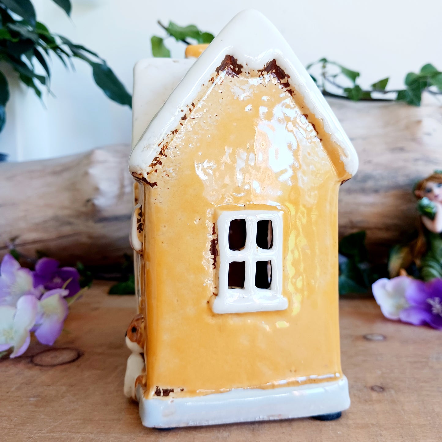 A gentle glow shines from Posh Paws, where tiny windows flicker with warmth as if welcoming beloved companions into a magical village haven. This Shudehill Village Pottery tealight house is crafted from ceramic, allowing candlelight to dance softly through its details, creating a comforting and enchanted atmosphere.