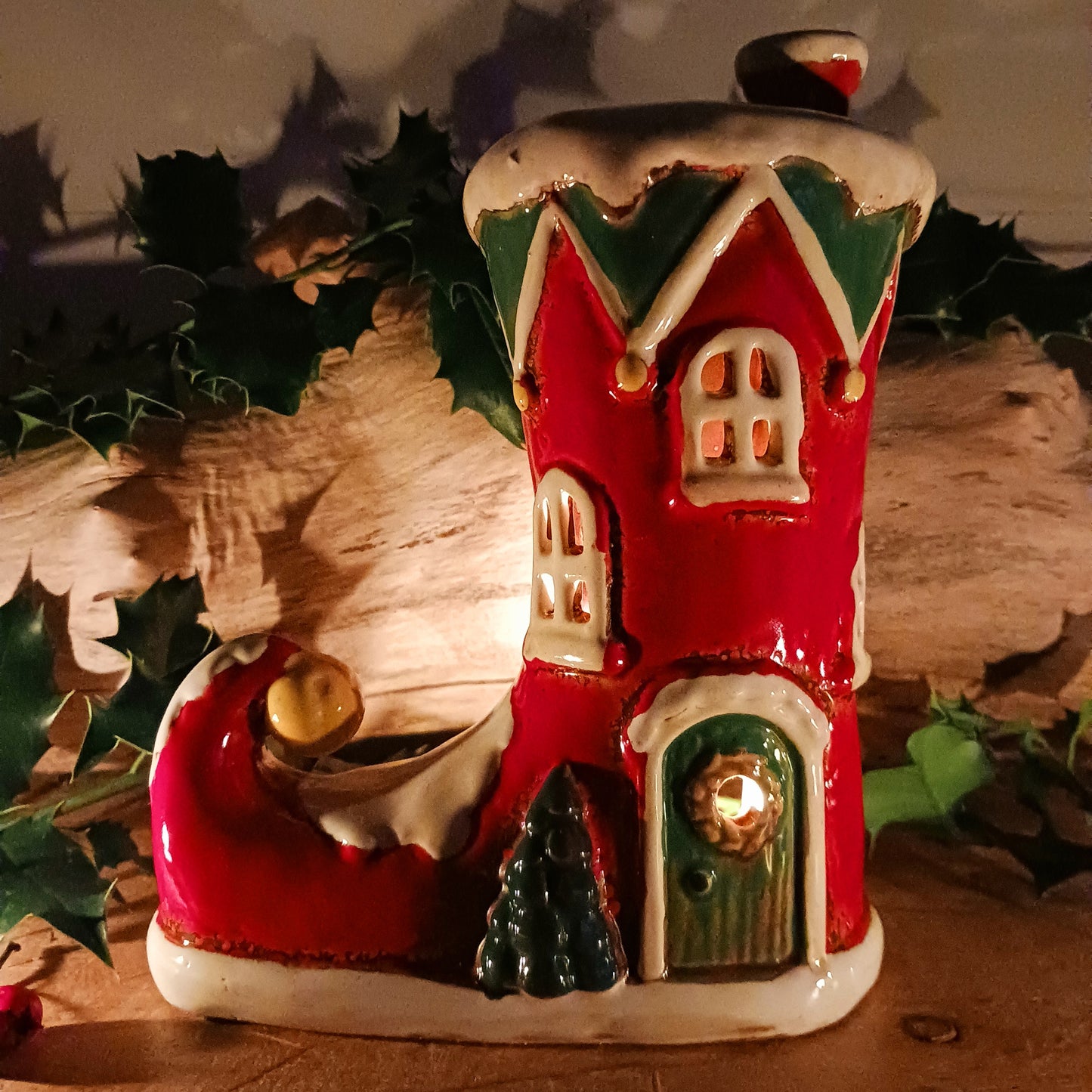 Step into the world of festive enchantment with the Village Pottery Christmas Elf Boot House Tealight Holder, a playful handcrafted ceramic creation bursting with Christmas spirit. Measuring 16 x 16 x 9.5 cm, this delightful piece takes the shape of a cheerful elf’s boot turned into a cosy little house, complete with twinkling windows and snowy details.