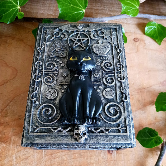 From the macabre masters at Nemesis Now, this Black Cat Familiar Box is a must-have for any occult enthusiast. At its centre sits a mystical black cat familiar perched atop a horned skull, radiating dark enchantment and protective energy.