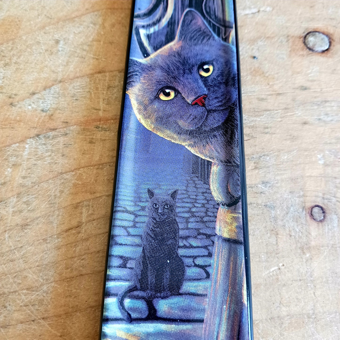 Bring a touch of magic into your home with the enchanting Rusty Cauldron Incense Burner by renowned fantasy artist Lisa Parker. Featuring her iconic artwork, this beautifully crafted piece captures a mystical feline perched atop a barrel outside the legendary Rusty Cauldron, while another curious cat watches the magical high street unfold behind.