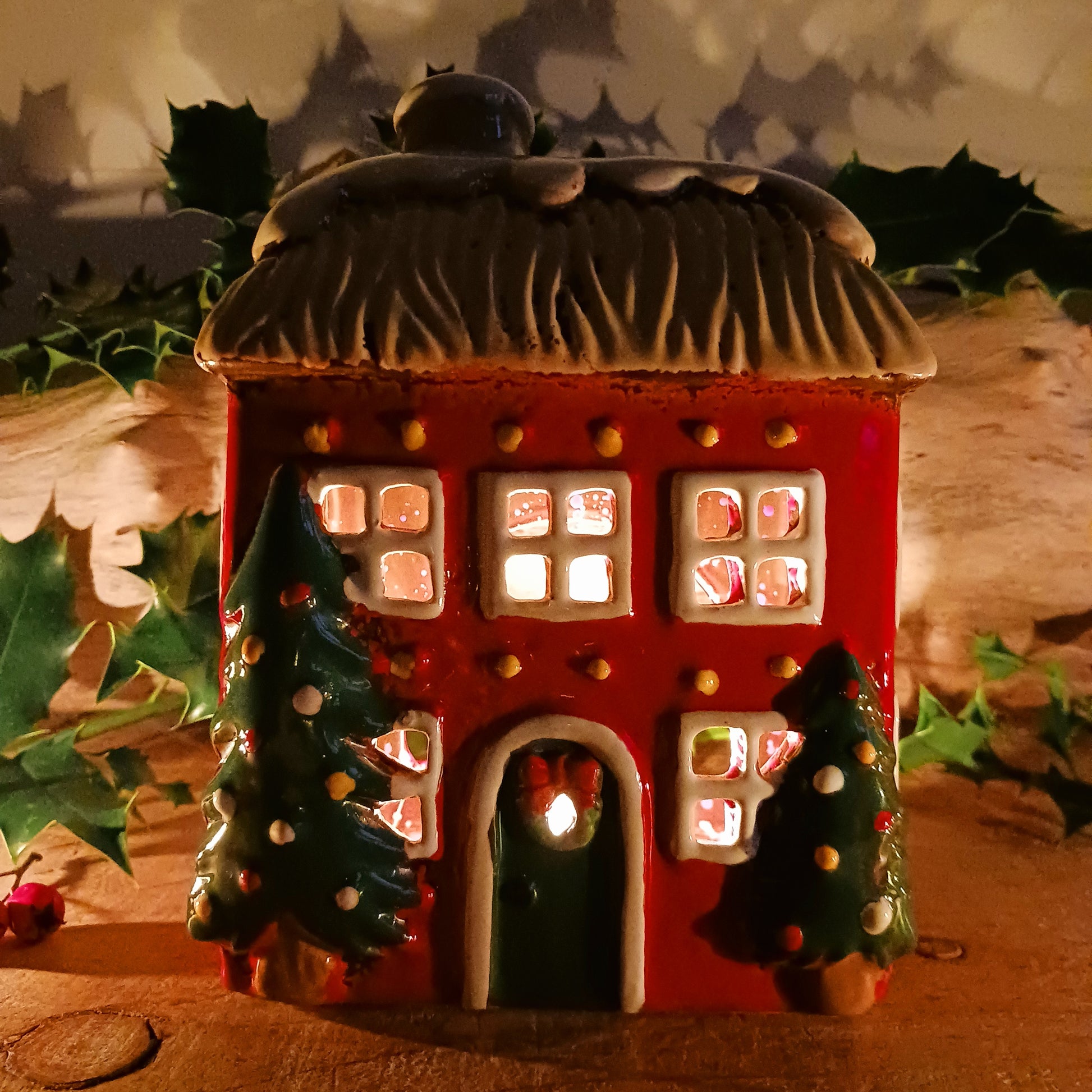 Bring timeless festive charm into your home with the Village Pottery Christmas Thatched Roof House Tealight Holder, a handcrafted ceramic cottage glowing with the spirit of the season. Measuring 17 x 12.5 x 8.5 cm, this enchanting piece captures the essence of a peaceful winter’s night — where golden candlelight flickers through snowy windows beneath a soft thatched roof.