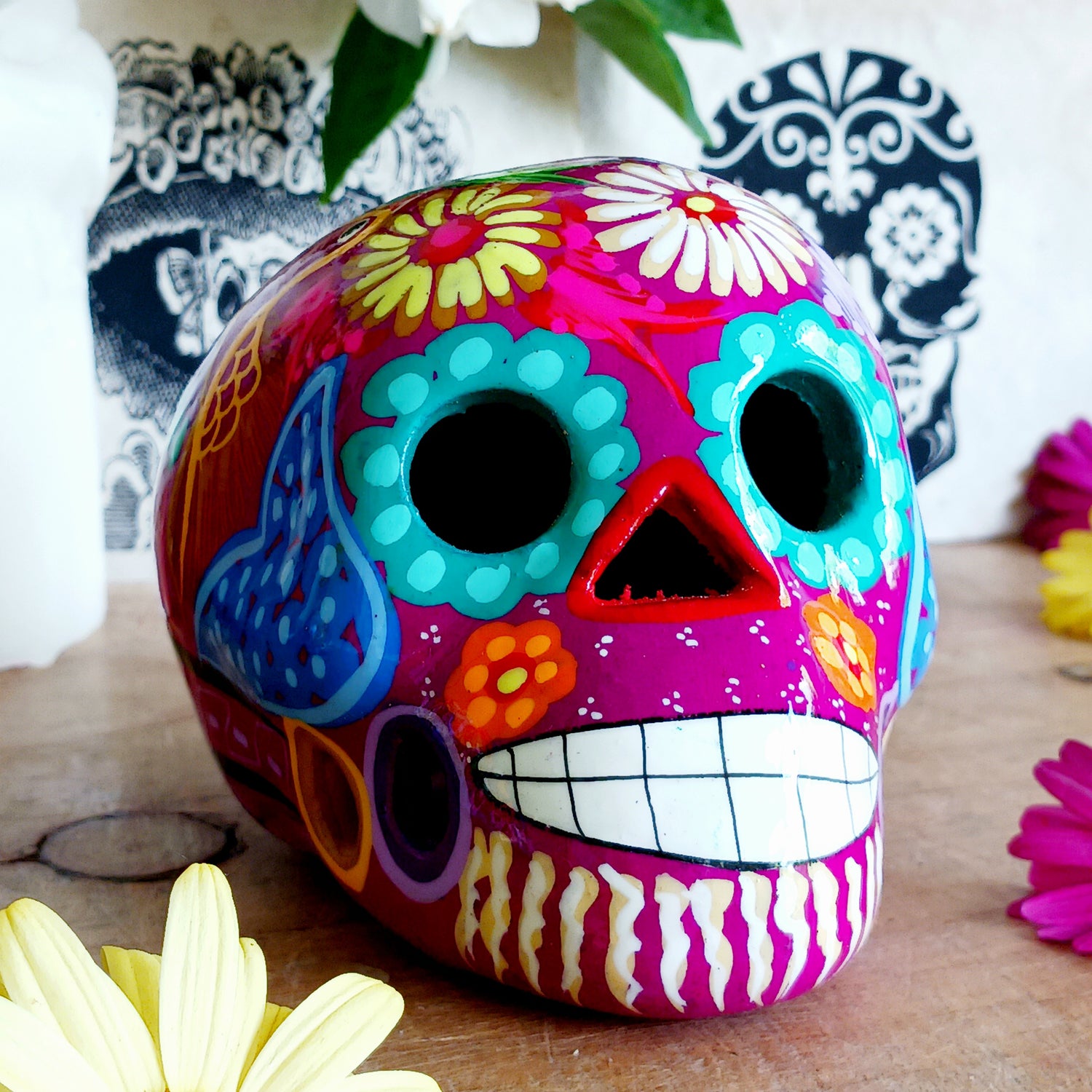 These fun ceramic sugar skull ornaments have been beautifully painted in bright colours and finished with a high shine glaze. They are a popular item during Día de Los Muertos or Day of the Dead festivities, held in Mexico every November to celebrate welcoming the souls of their deceased relatives back for a time of food, drink and celebration.