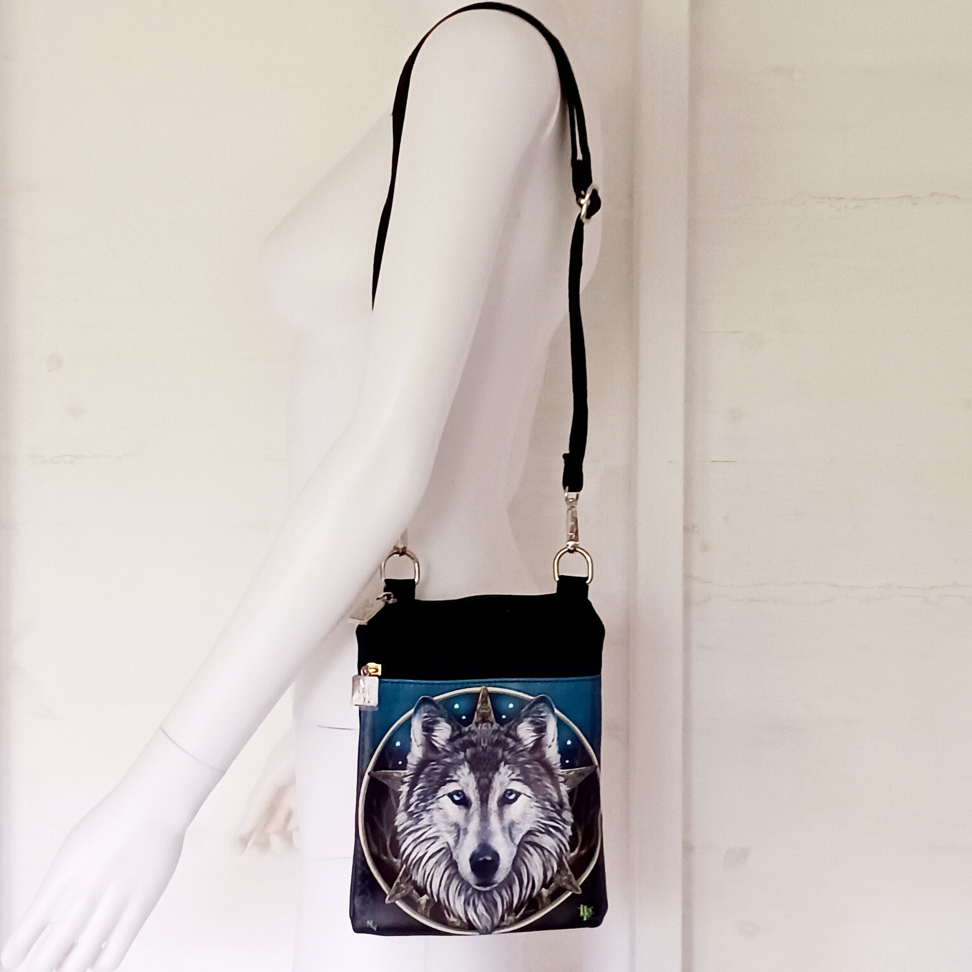 Step into the wild with this visually striking Lisa Parker Wolf Shoulder Bag, from Nemesis Now. Featuring artwork from the renowned fantasy and wildlife artist Lisa Parker, this bag captures the raw spirit of nature and mysticism.
