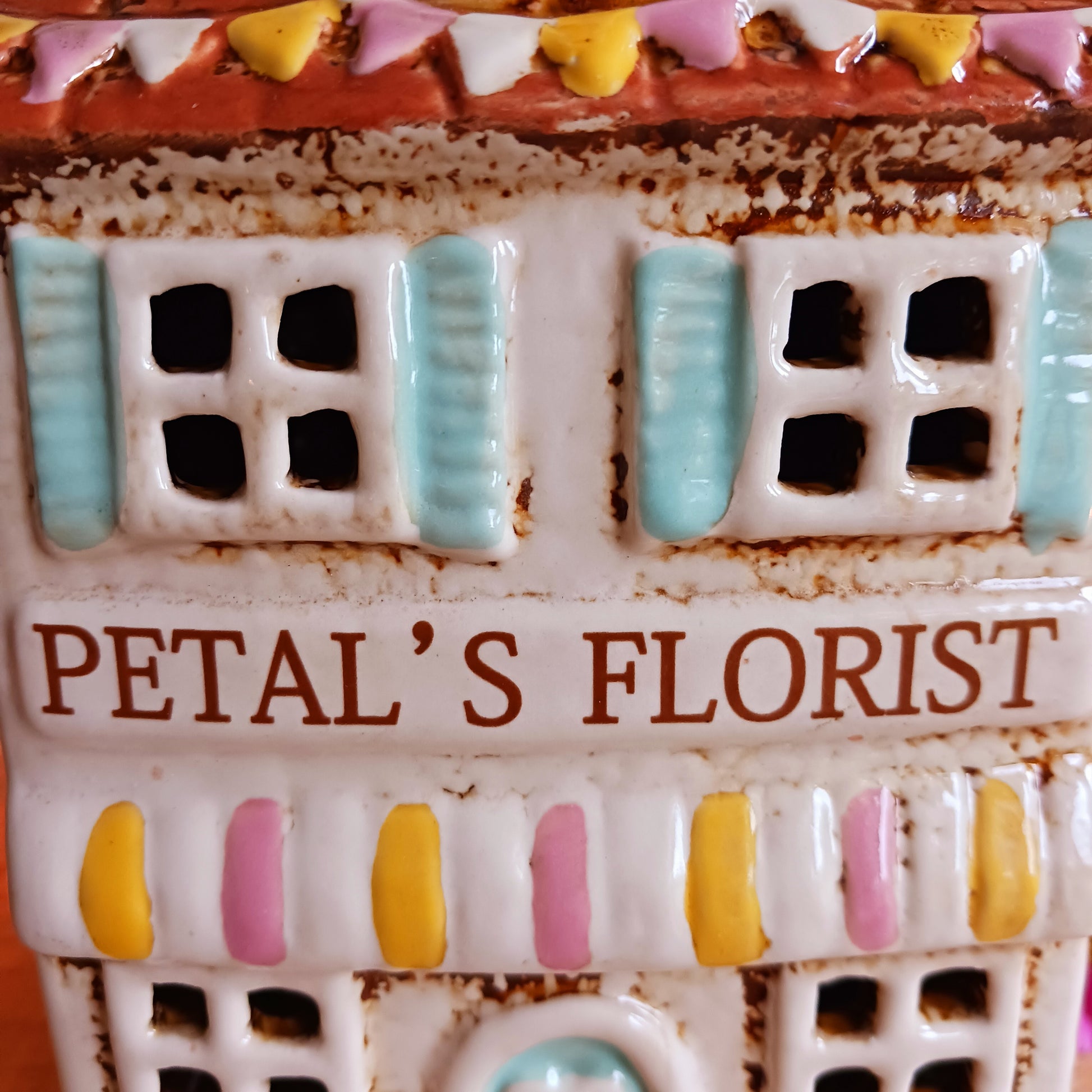 Handcrafted in the Village Pottery workshop, this Florist Tealight Holder is a true collectible from the Shudehill Collection. Made from fine ceramic with intricate detailing, it captures the nostalgic charm of a festive florist shop in a snow-dusted winter village scene.