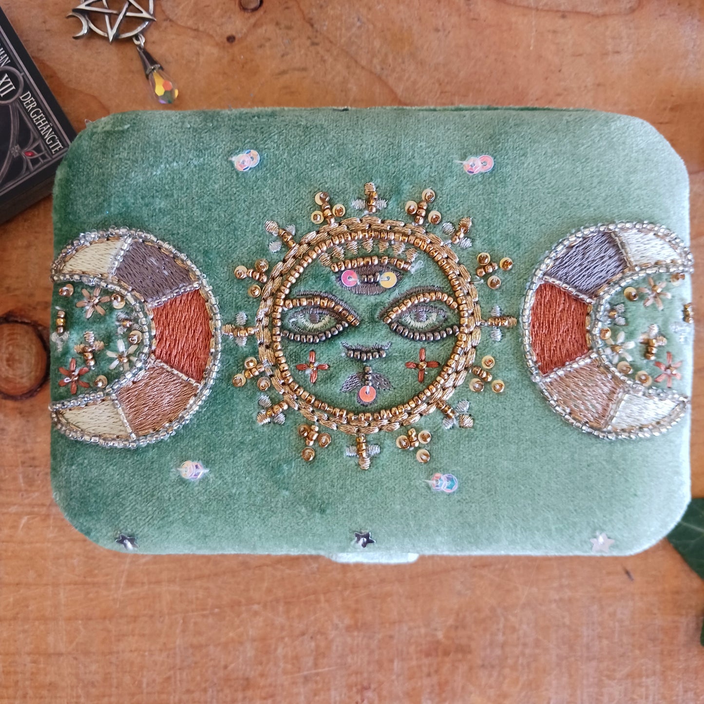 Elegant green triple moon velvet box with fine embroidery and beads. Perfect for jewellery, tarot cards, and crystals. Secure strap closure for treasured items.